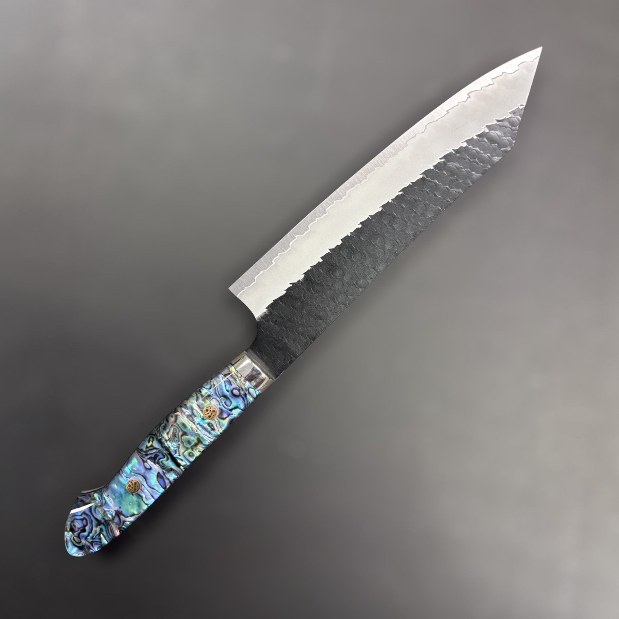 Nigara SG2 Kurouchi Tsuchime Kiritsuke 210 mm, left side profile highlighting kurouchi cladding and iridescent handle.