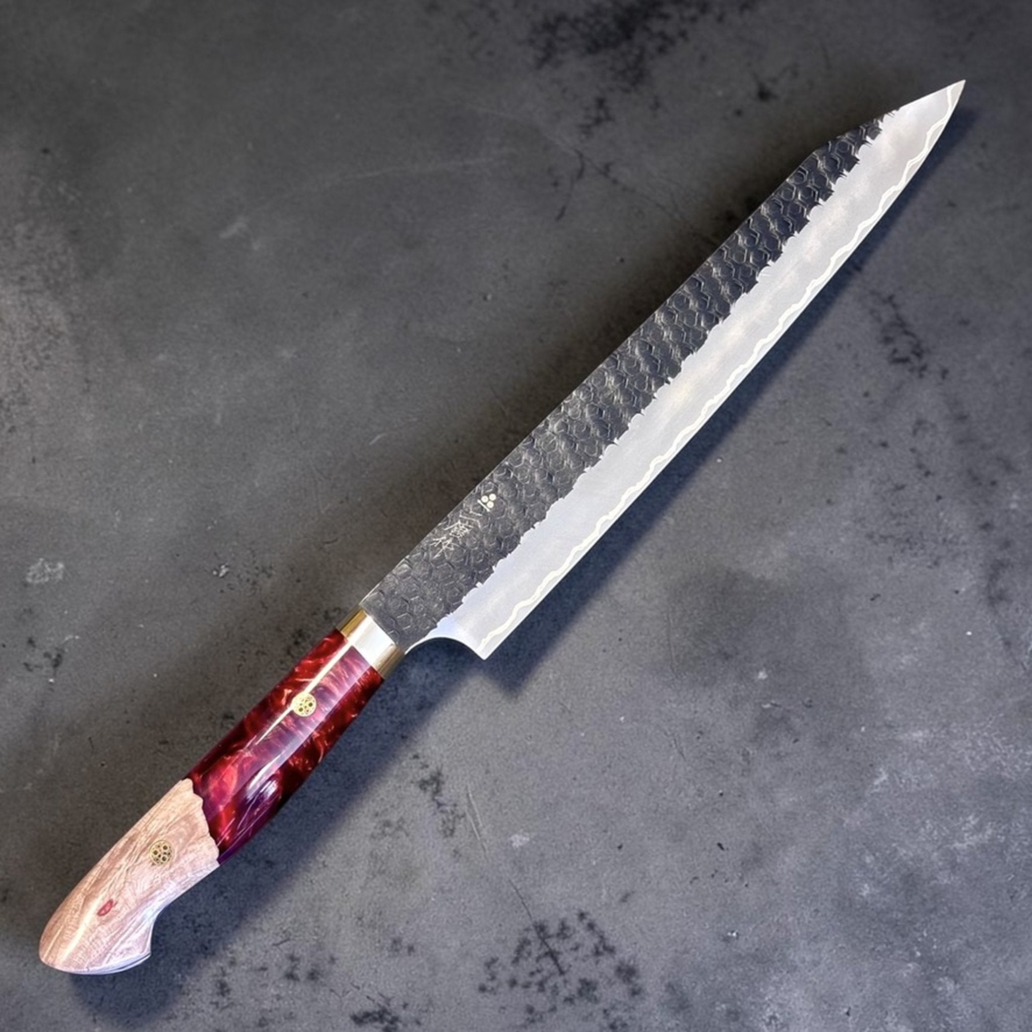 Nigara SG2 Kurouchi Tsuchime Sujihiki 255 mm with hybrid western handle, angled reverse view showing blade profile and handle detail.