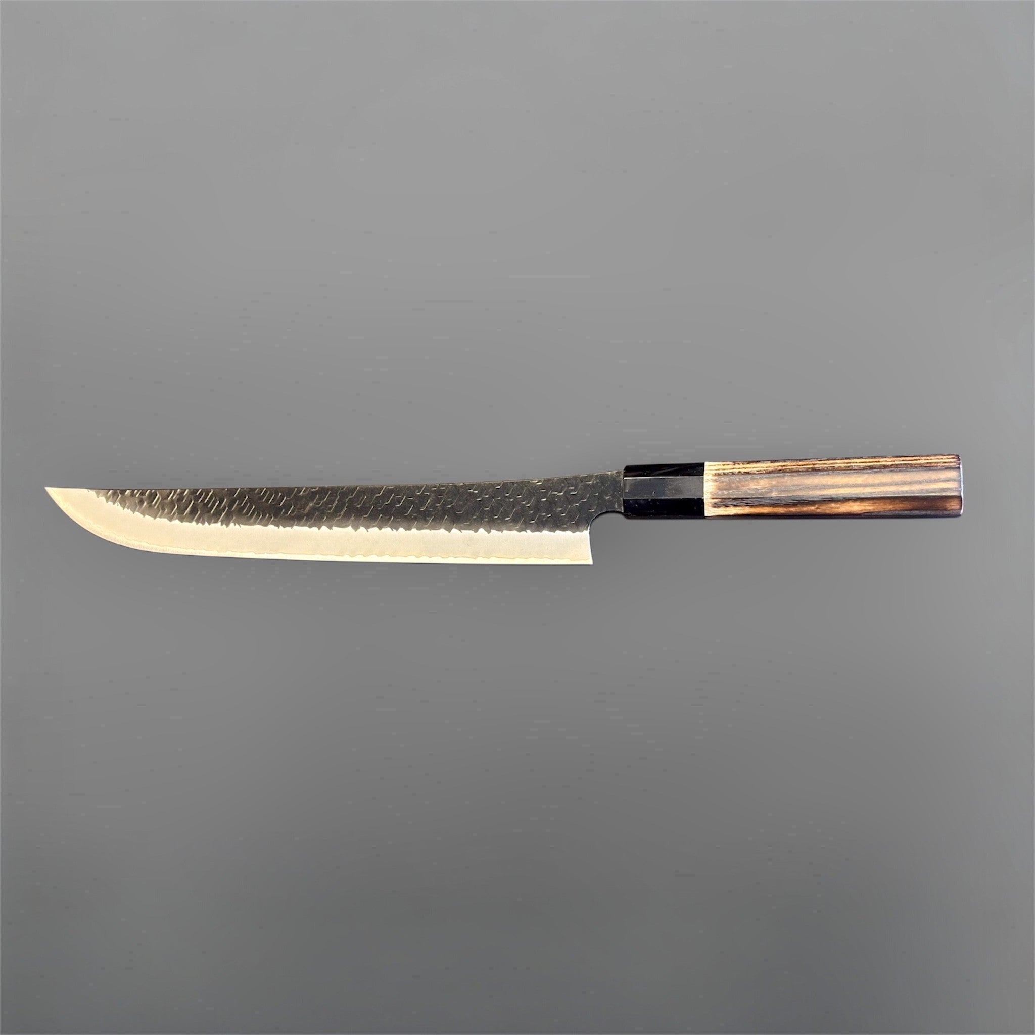 Nigara SG2 Tsuchime Kurouchi Sakimaru Sujihiki 270 mm, full side profile showing the slender slicer blade and contrasting wood wa handle.