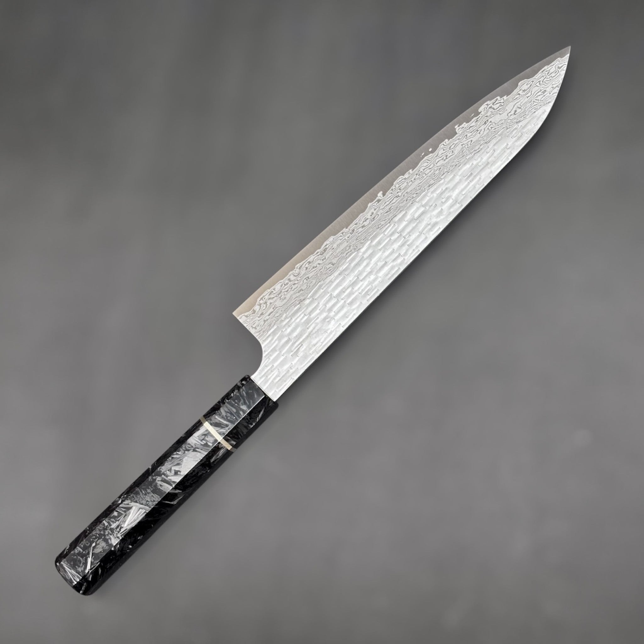 Nigara VG-XEOS Tsuchime Gyuto 210 mm with carbon fiber handle, close-up view highlighting hammered tsuchime finish and blade geometry. Left side of knife.