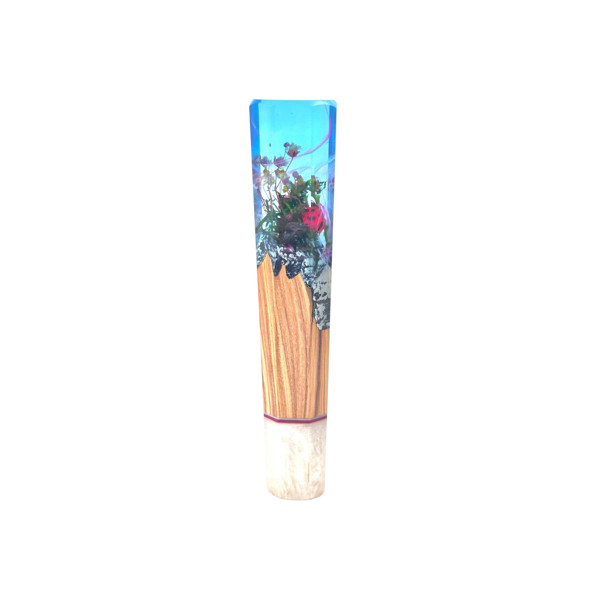 Prisma Knife “Ladybug’s Dream” custom wa handle — crystal‑clear sky‑blue resin encapsulating miniature flowers and a red ladybug above olive‑brown wood core, reverse view, isolated on white.