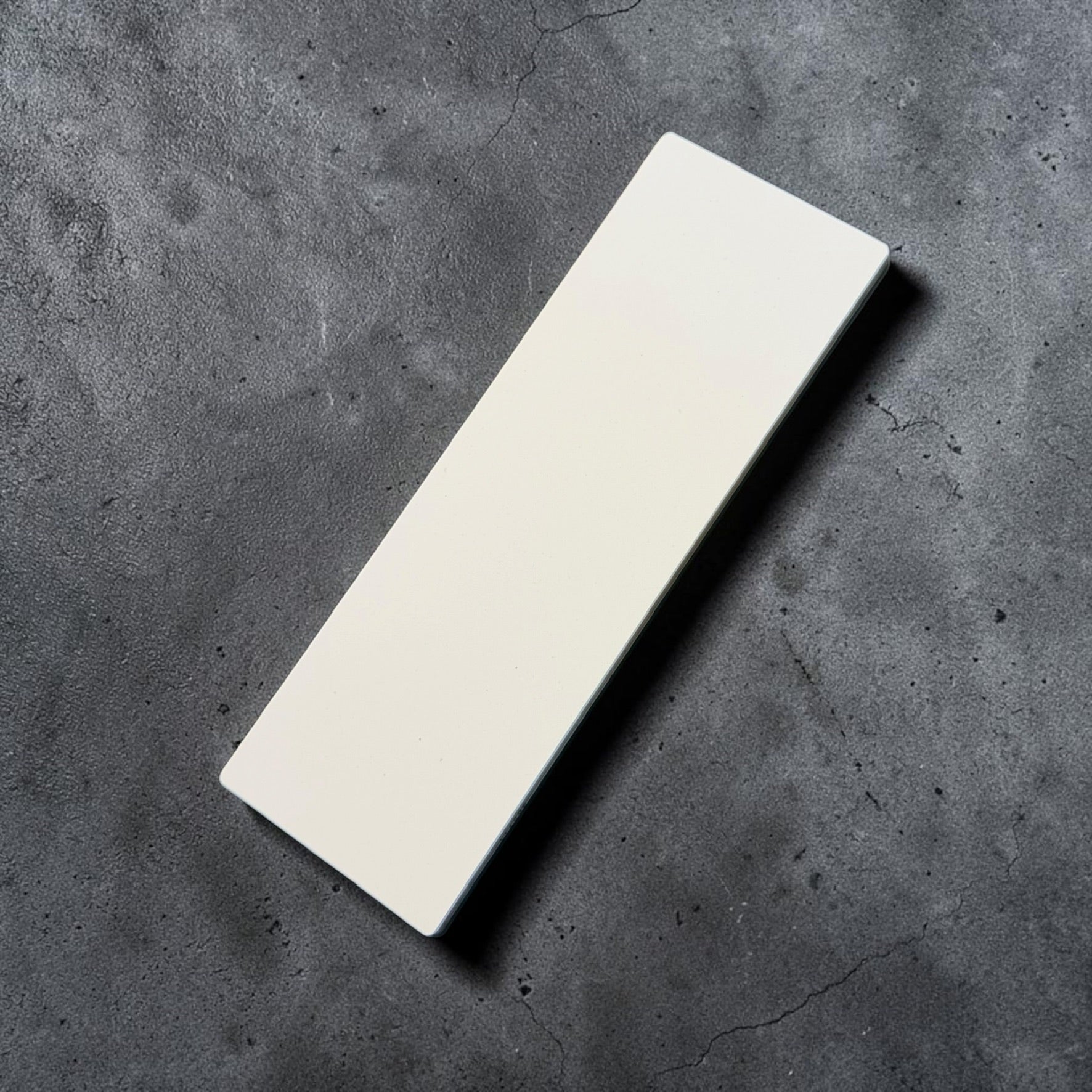 Shapton GlassStone 2000 grit ceramic whetstone top surface on dark background
