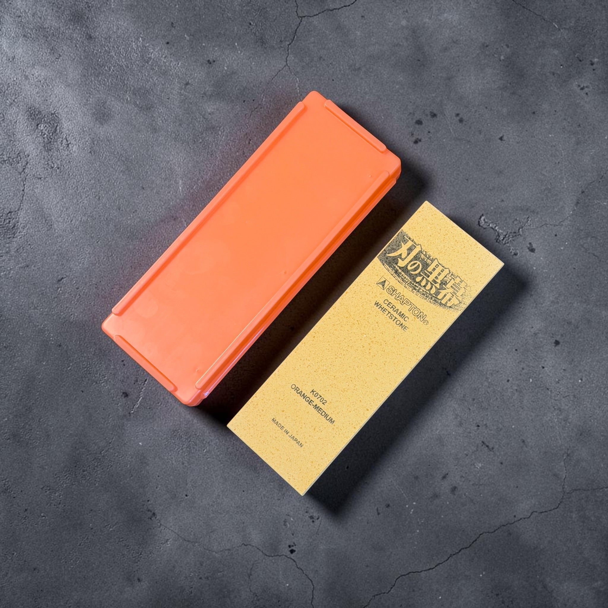 Shapton Kuromaku K0702 1000 grit whetstone beside its orange storage case