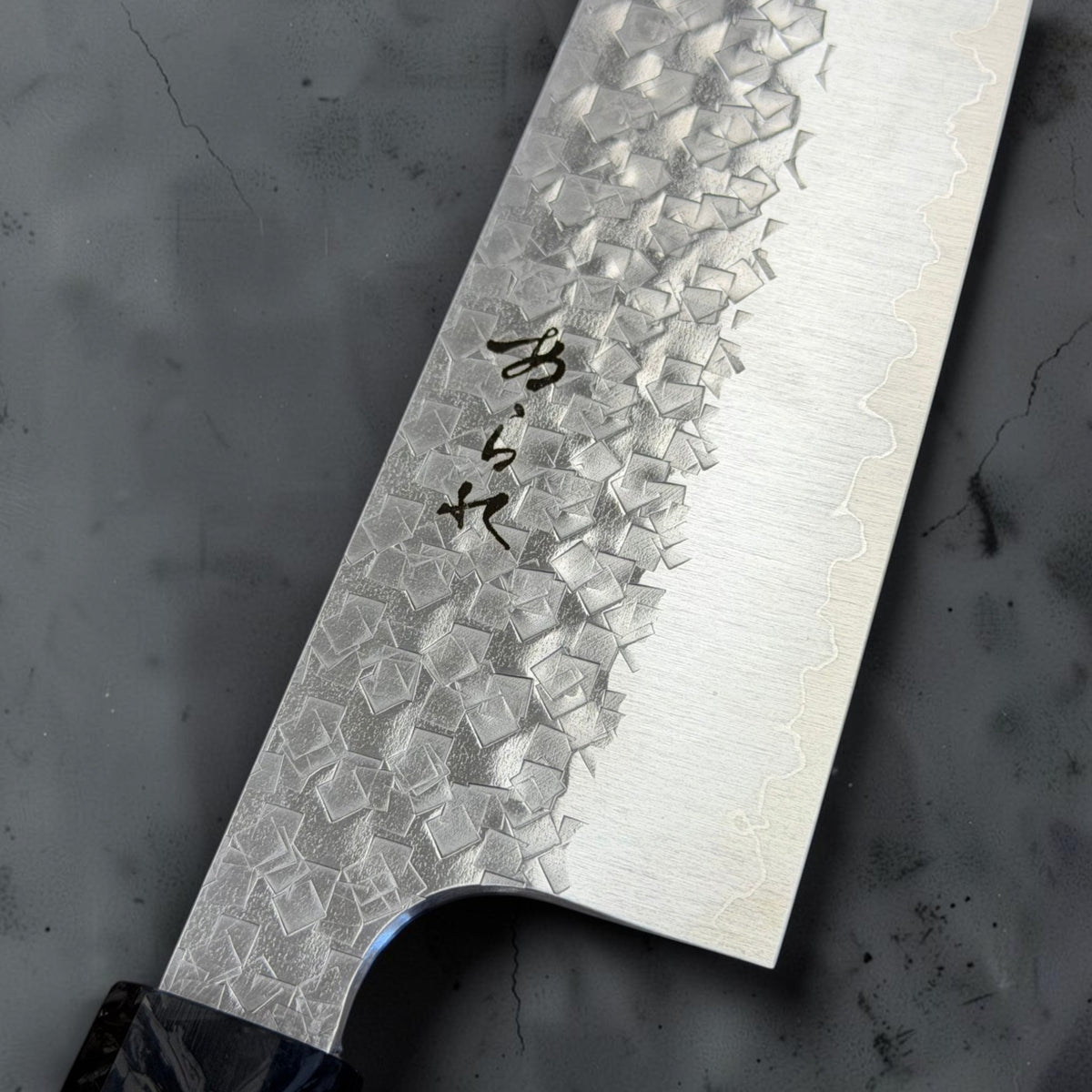 Close-up of the Shibata Arare blade engraving, square hammered pattern and stainless cladding line.