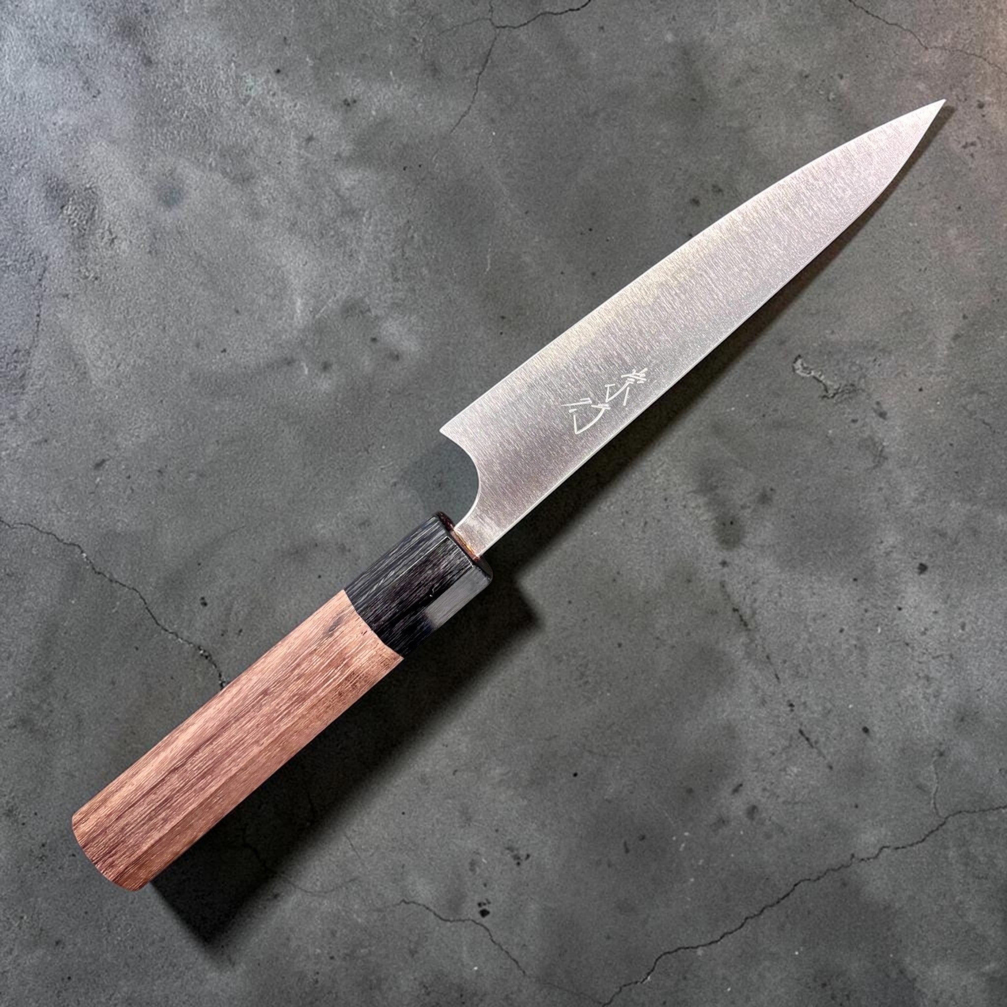 Shibata Koutetsu Aogami Super Petty 135 mm, left‑side profile with maker’s kanji on blade, walnut/ebony wa handle against black background.
