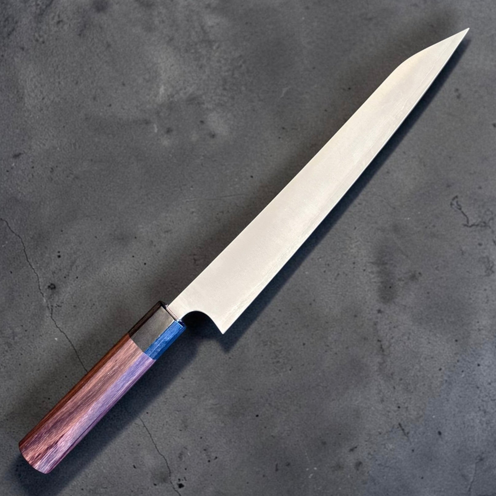 Shibata Koutetsu Chromax Sujihiki 240 mm with wa handle, angled full-knife view on dark textured background.