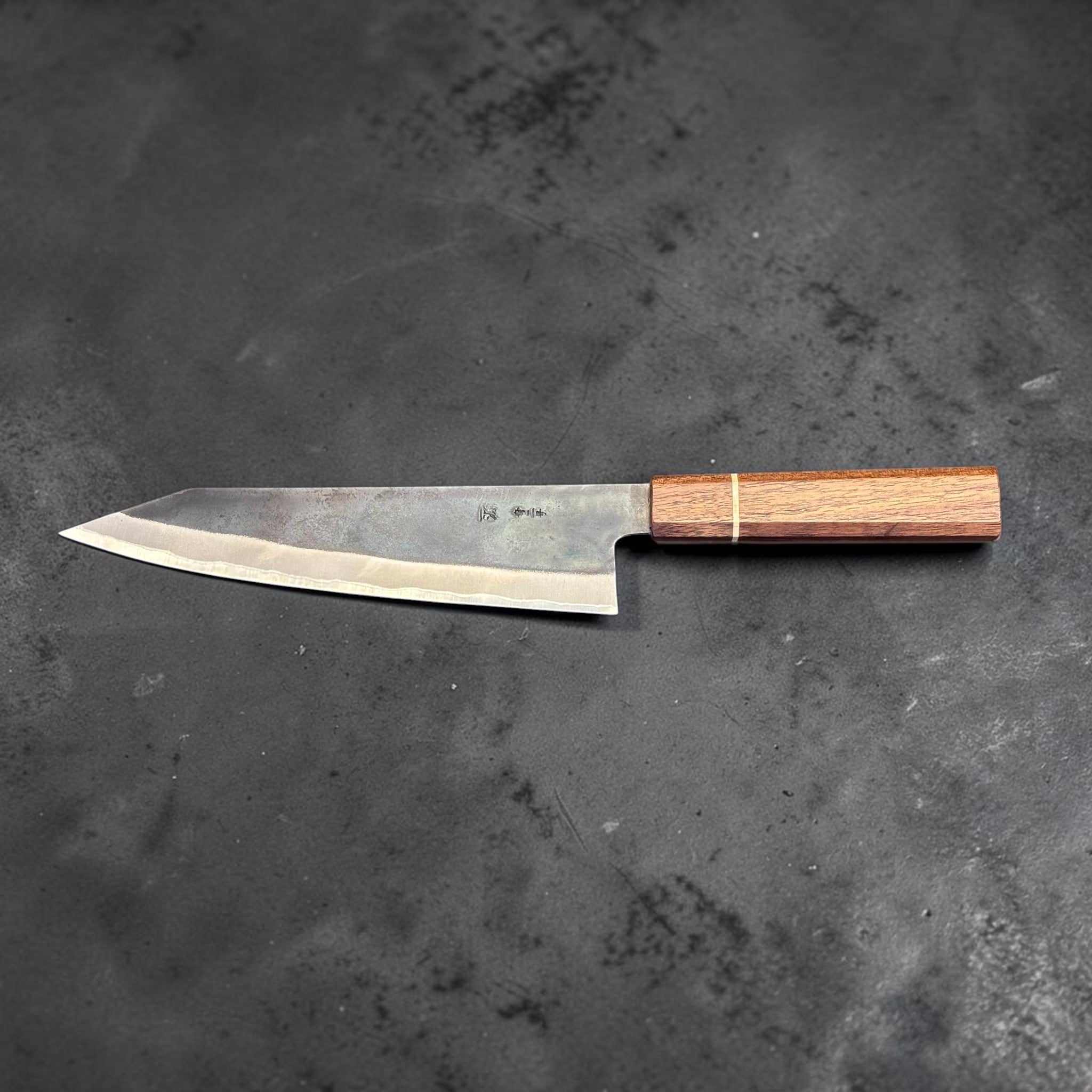 Shigeki Tanaka Stainless-Clad Blue #2 Kurouchi Kiritsuke 210 mm with Sanjo walnut handle, full side profile on dark stone background.