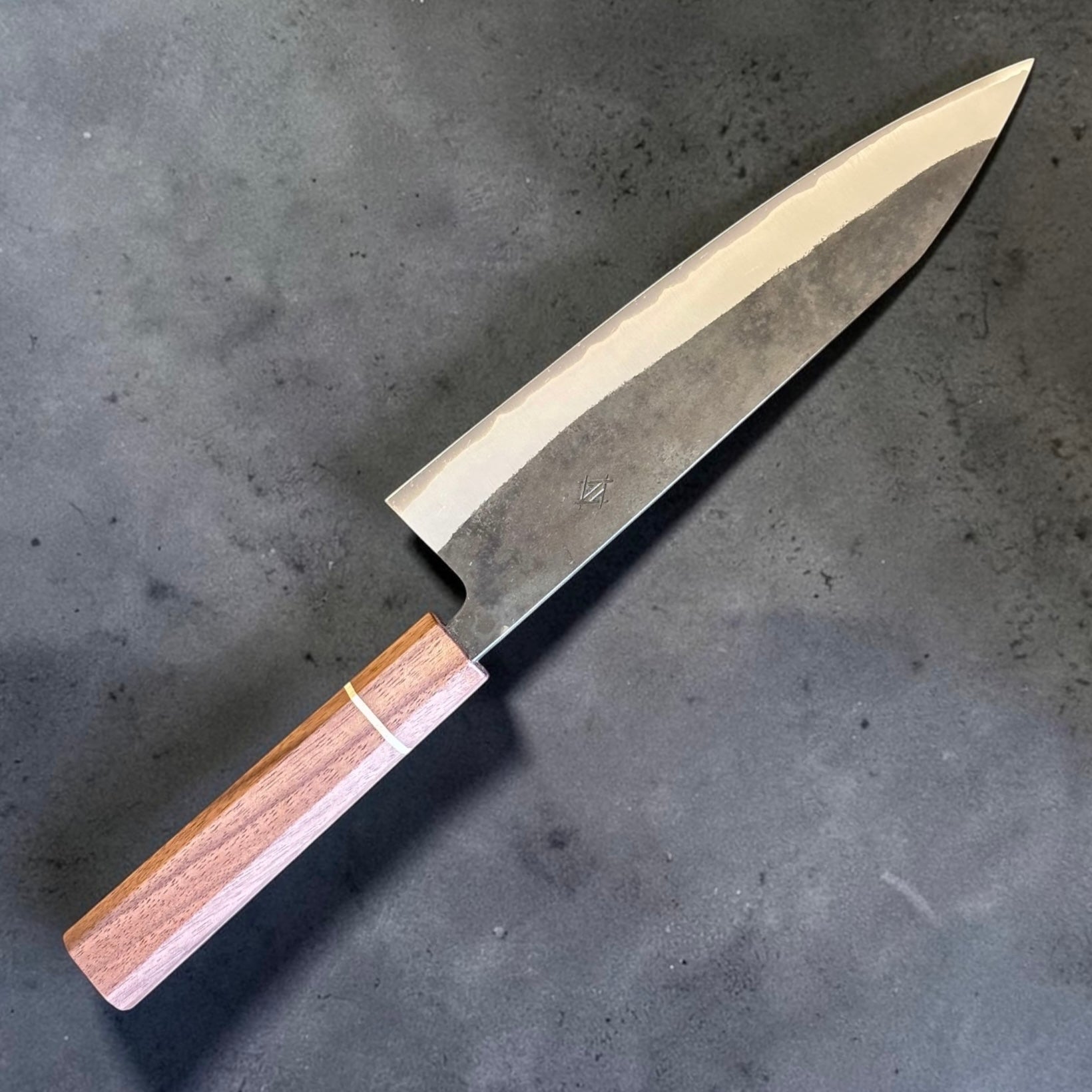 Angled view of Shotaro Imai Aogami Super Kurouchi Gyuto 218mm with hand-installed Sanjo walnut and maple stripe wa handle
