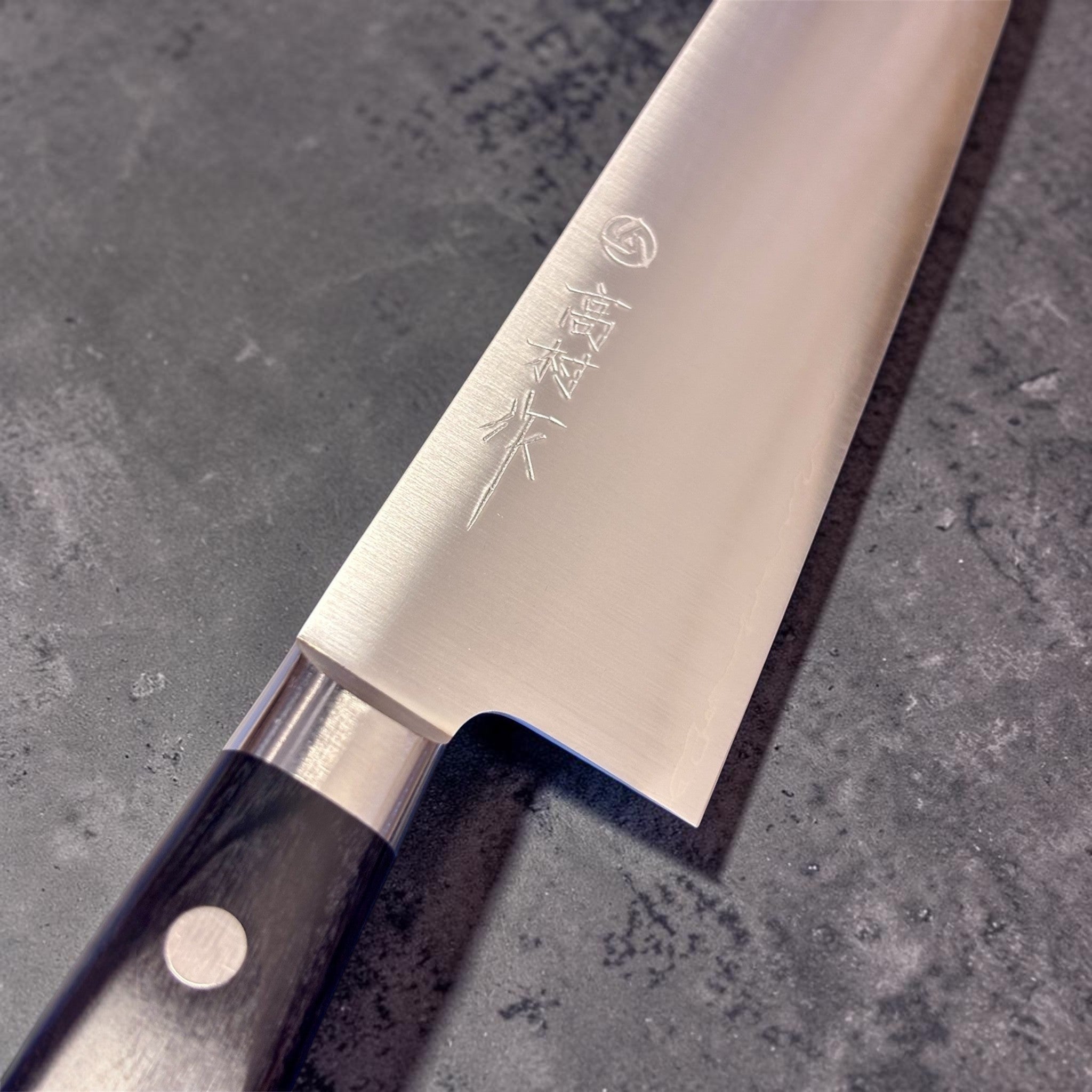 Takamura VG-10 Migaki Gyuto 210 mm, close-up of the blade face and engraved Takamura maker mark.