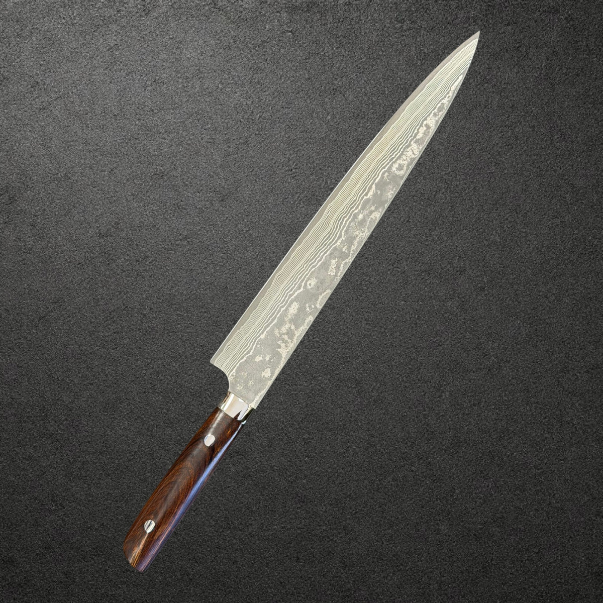 Reverse angled view of the Saji 270mm VG-10 black Damascus sujihiki and ironwood handle