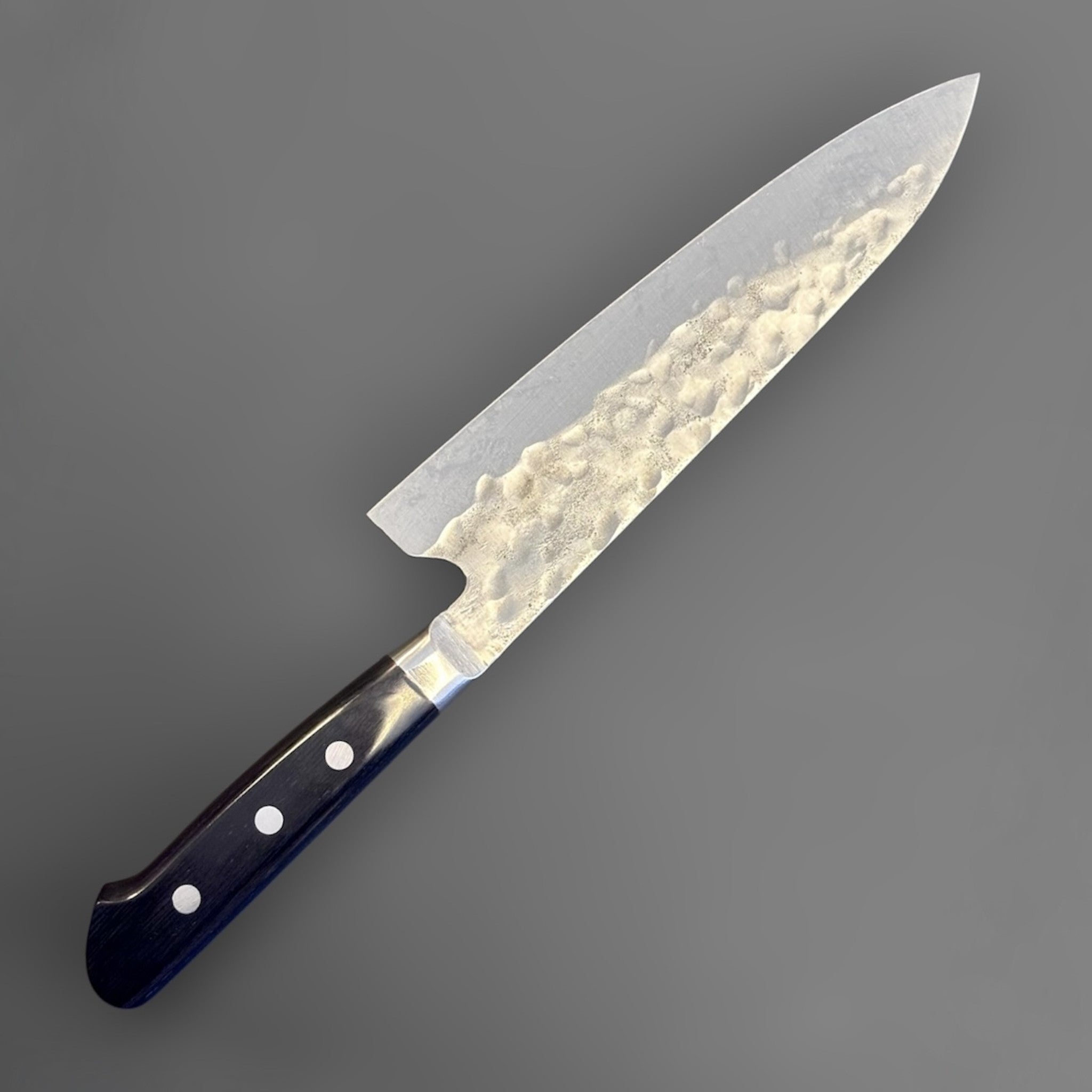 Teruyasu Fujiwara Maboroshi Gyuto 195 mm with western handle, three-quarter back view with maker's mark visible on the blade face.