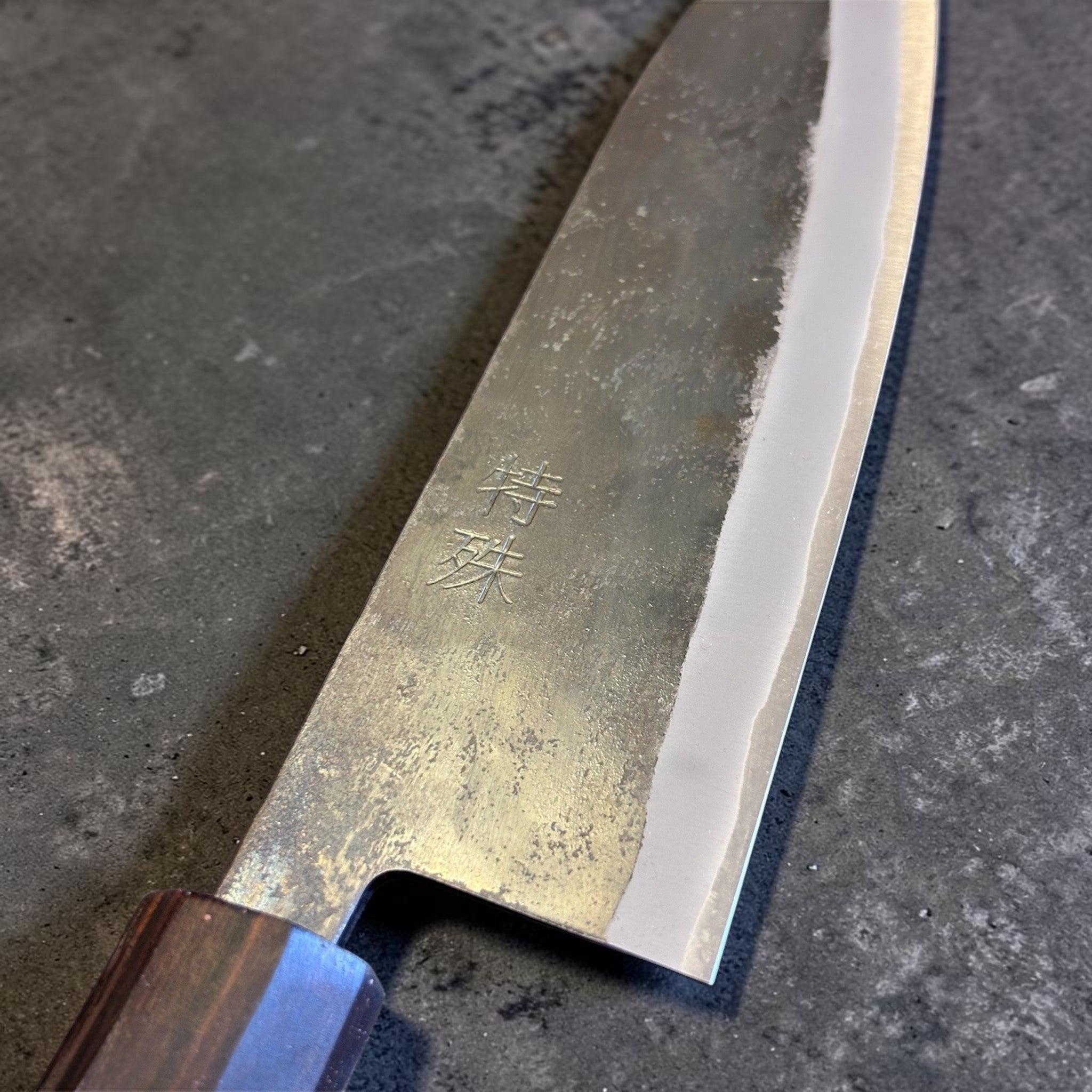 Tokushu Knife Rosewood Series White #2 Kurouchi 165 mm Japanese santoku knife, close-up of the blade face with kanji engraving and kurouchi texture.