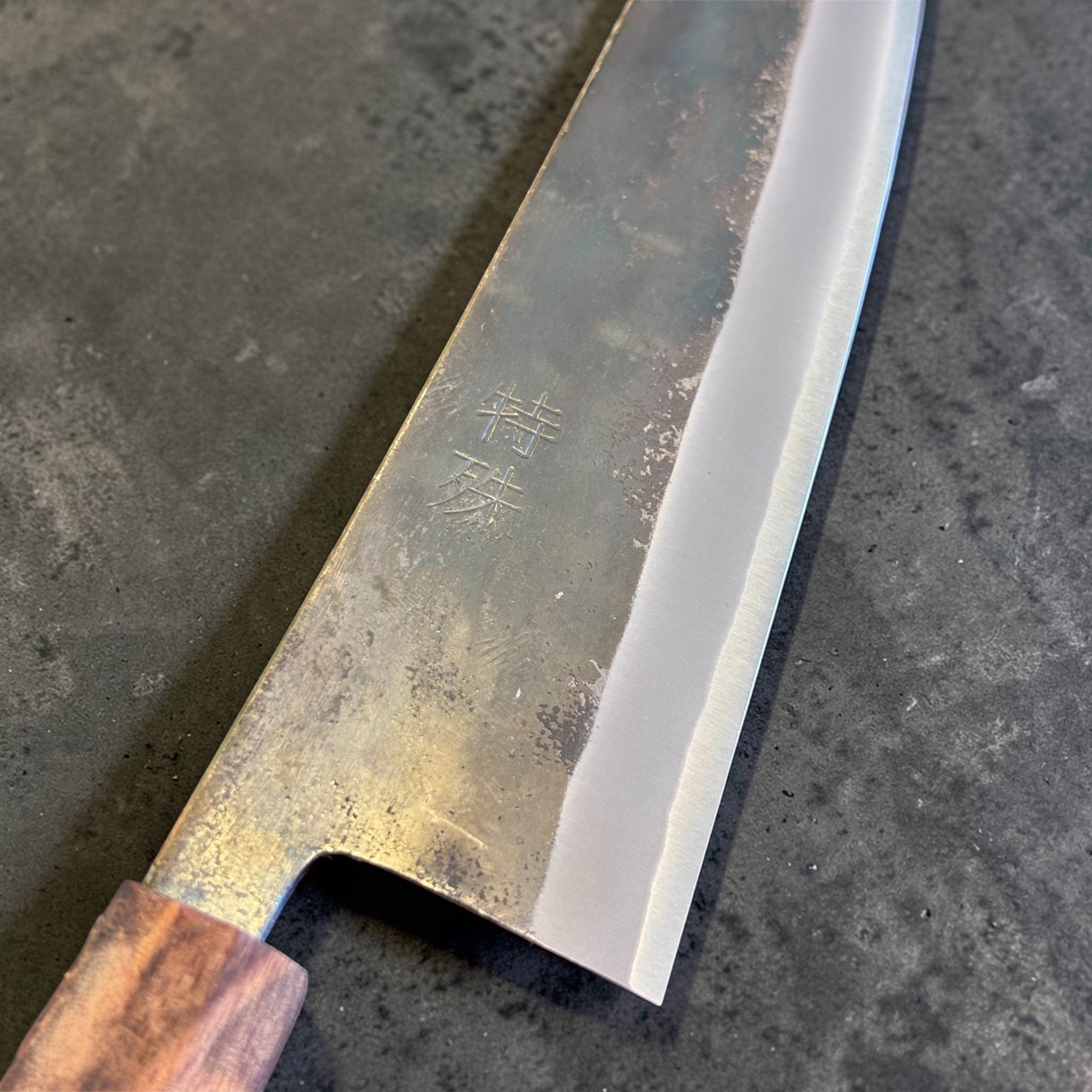 Tokushu Knife Rosewood Series White #2 Kurouchi 210 mm Japanese gyuto knife, close-up of the blade face with kanji engraving and kurouchi texture.