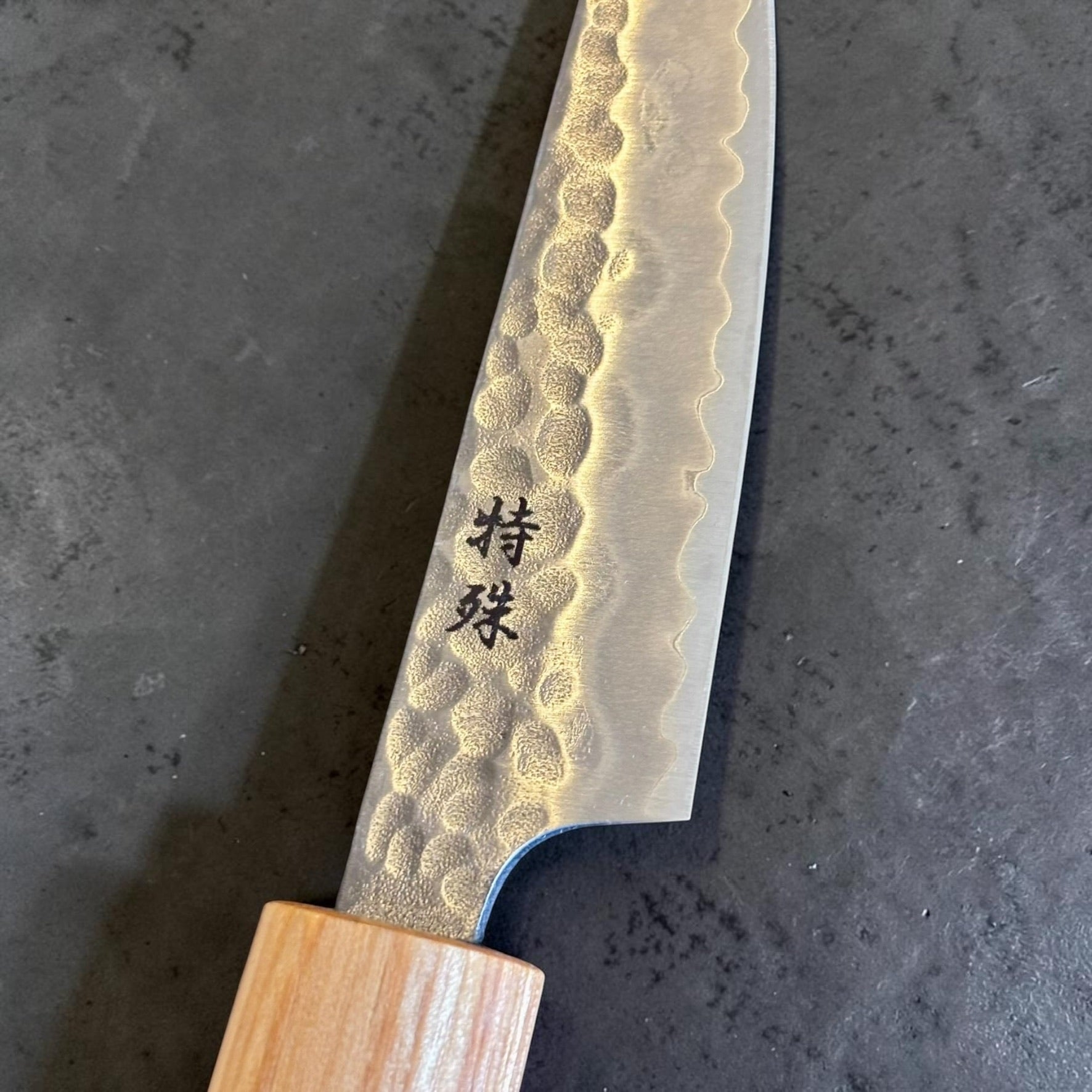 Close-up of Tokushu Knife Stainless Clad White #2 Tsuchime Petty 80mm showing kanji and hammered blade finish.