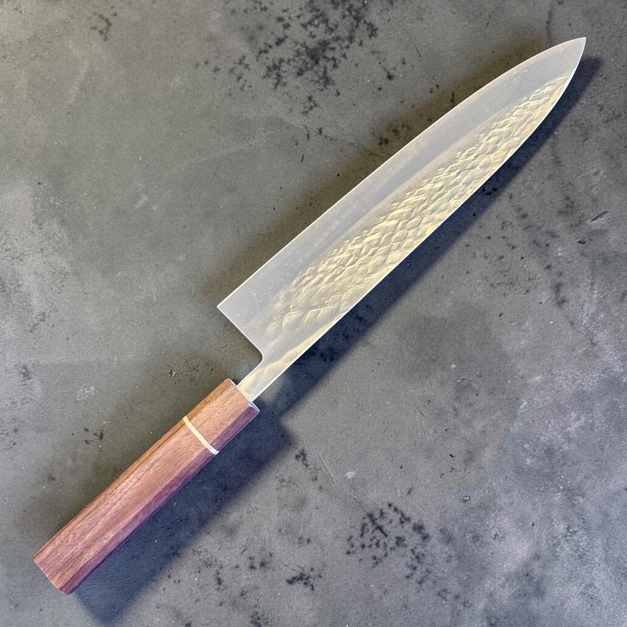 Tokushu Knife Tsuchime SLD Gyuto 240 mm, angled reverse-side view showing the hammered tsuchime finish and clean edge line.