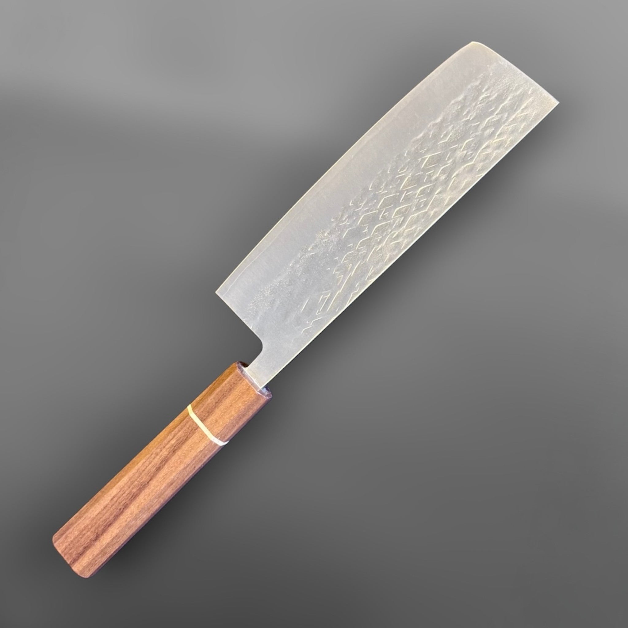 Tokushu Knife Tsuchime SLD Nakiri, angled reverse-side view with engraved kanji, tsuchime texture, and clean edge line.