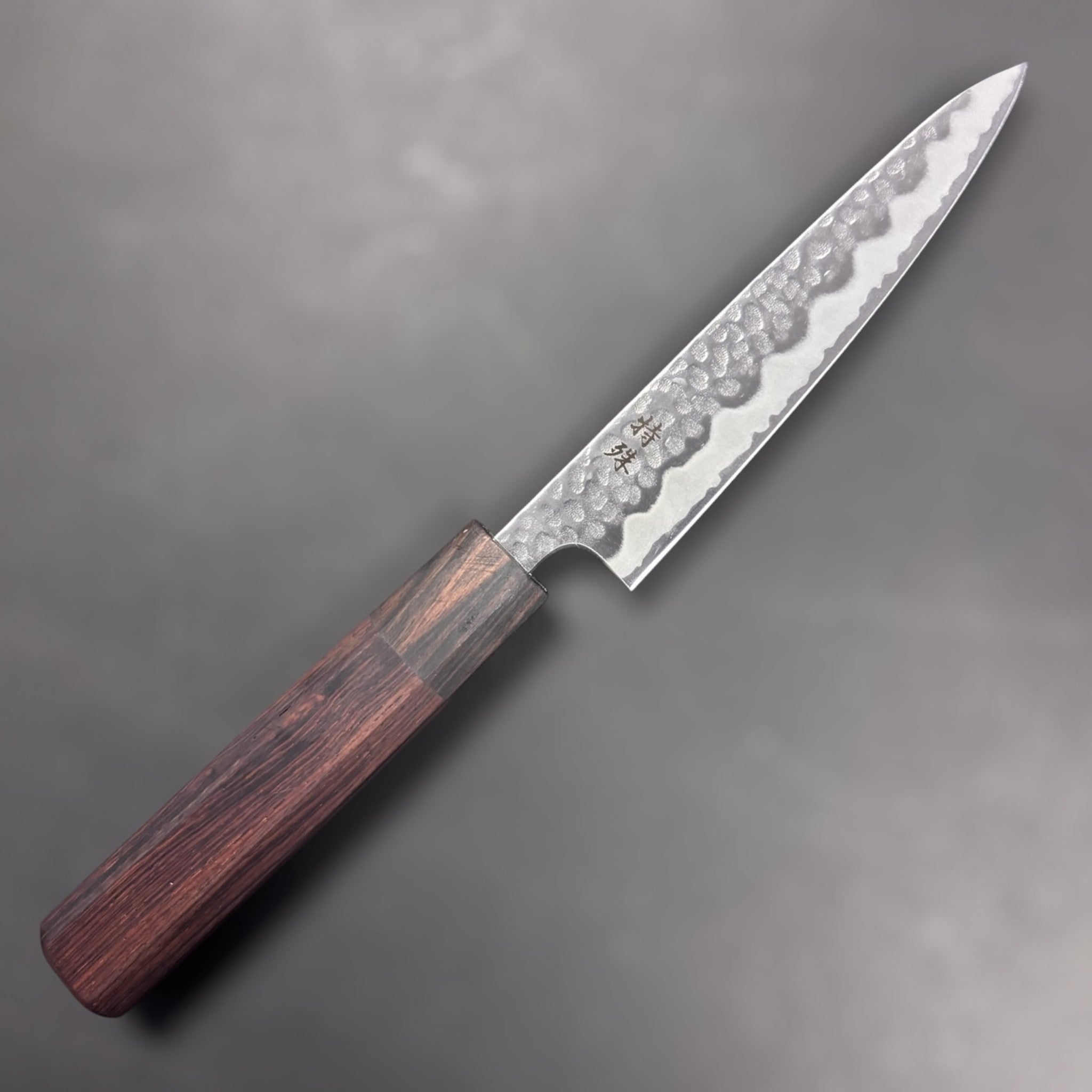 Tokushu Tsuchime White #2 Petty 135 mm with rosewood wa handle, front-right side profile of blade and handle on dark background