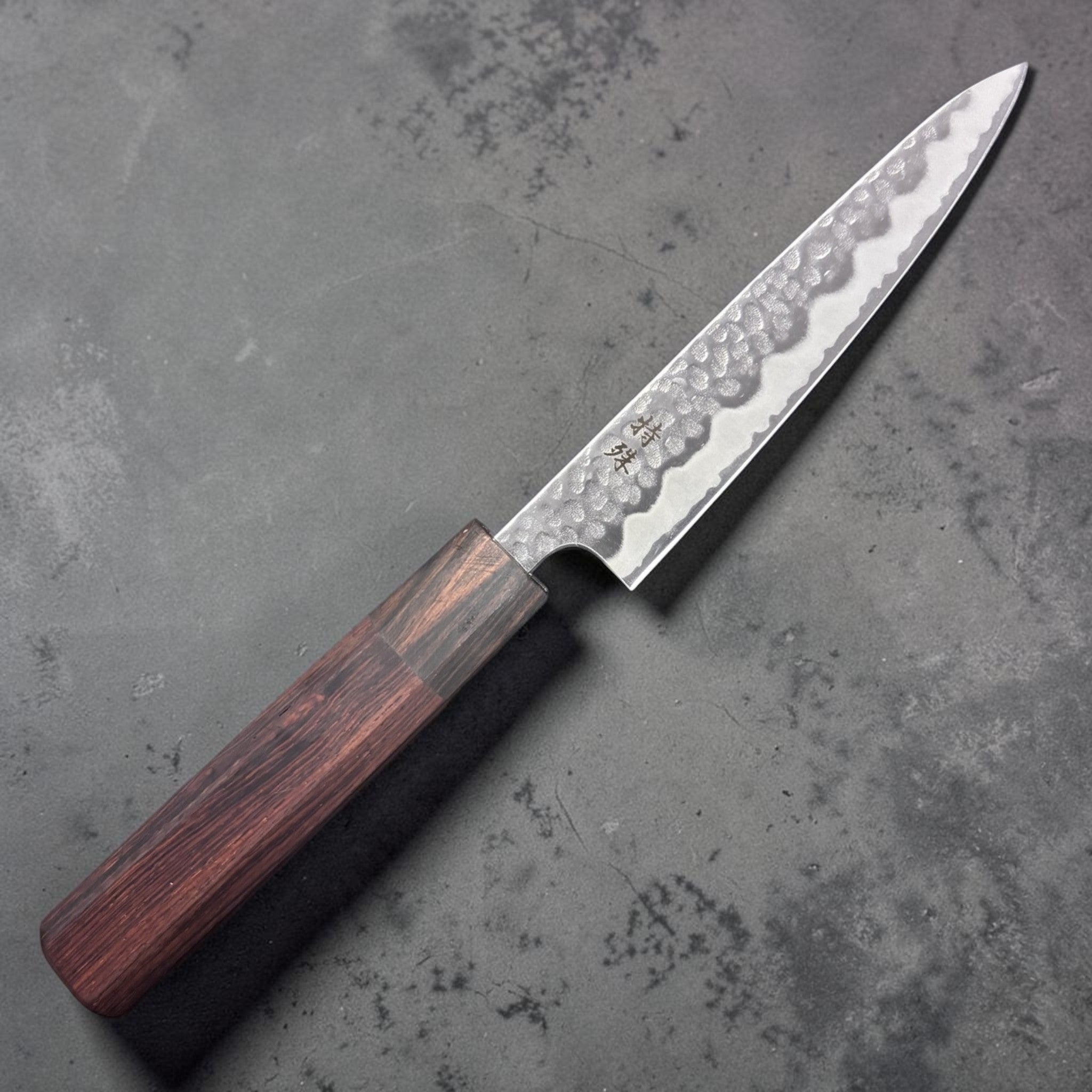 Tokushu Tsuchime White #2 Petty 135 mm with rosewood wa handle, front-right side profile of blade and handle on dark background
