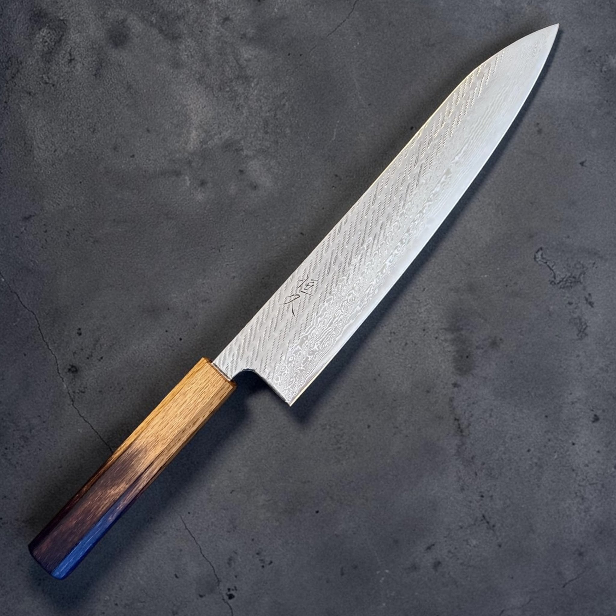 Tsunehisa AUS-10 Nawame Gyuto 240 mm with burnt oak handle, reverse angled view with kanji and blade pattern visible.