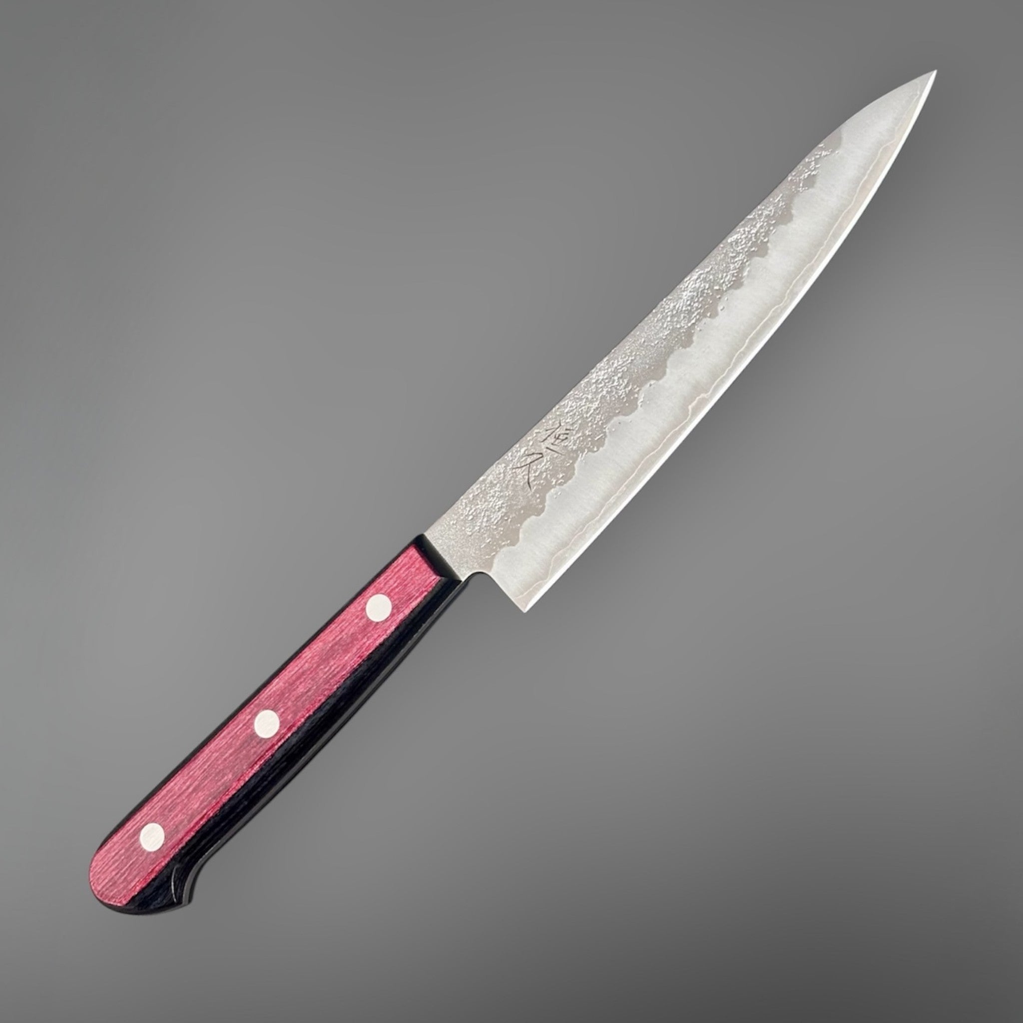Tsunehisa Ginsan #3 Nashiji Petty 135 mm with red pakkawood scales, diagonal product view highlighting the pointed petty profile and textured blade face.