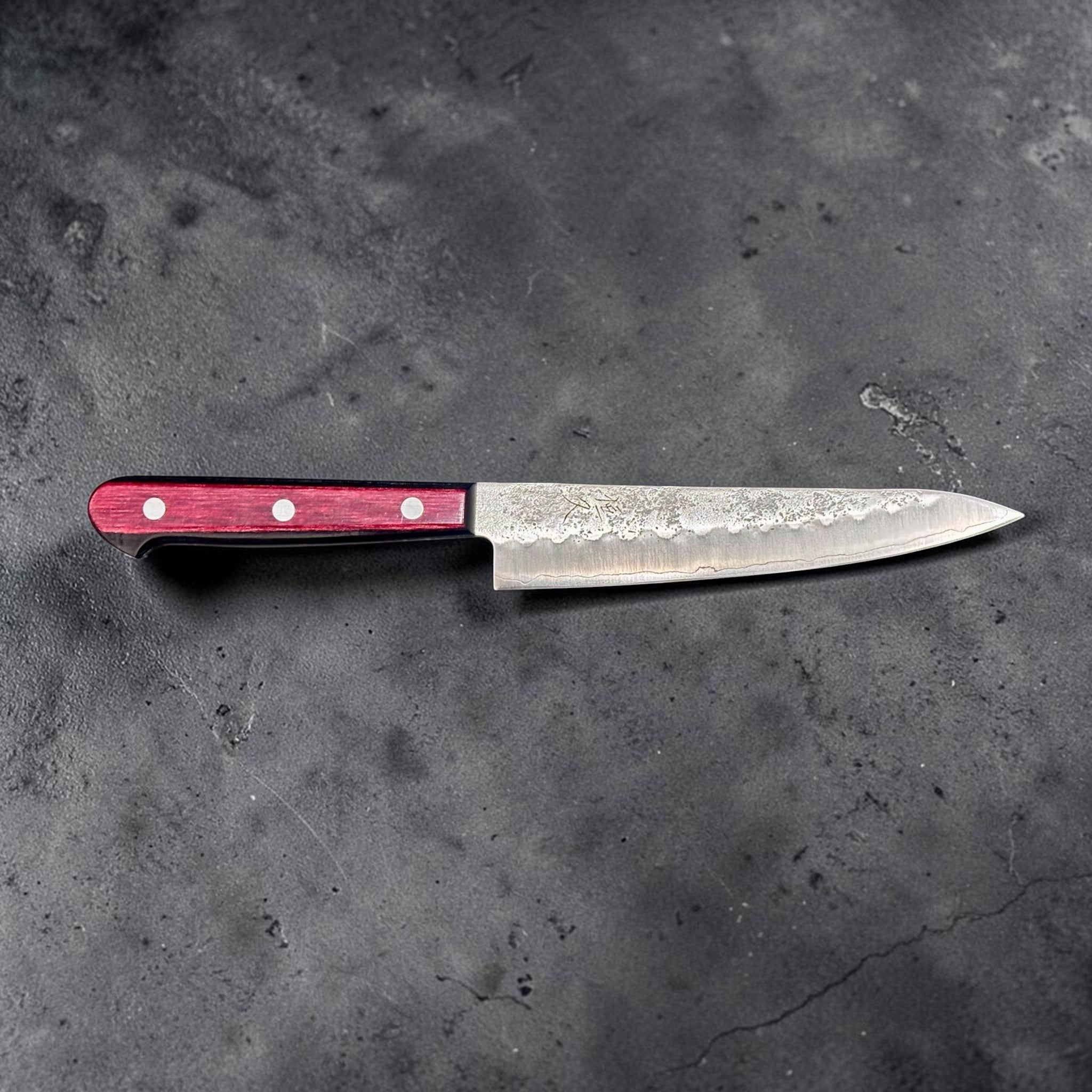 Tsunehisa Ginsan #3 Nashiji Petty 135 mm with red pakkawood scales, side profile showing the slender blade, nashiji finish, and red three-rivet handle.