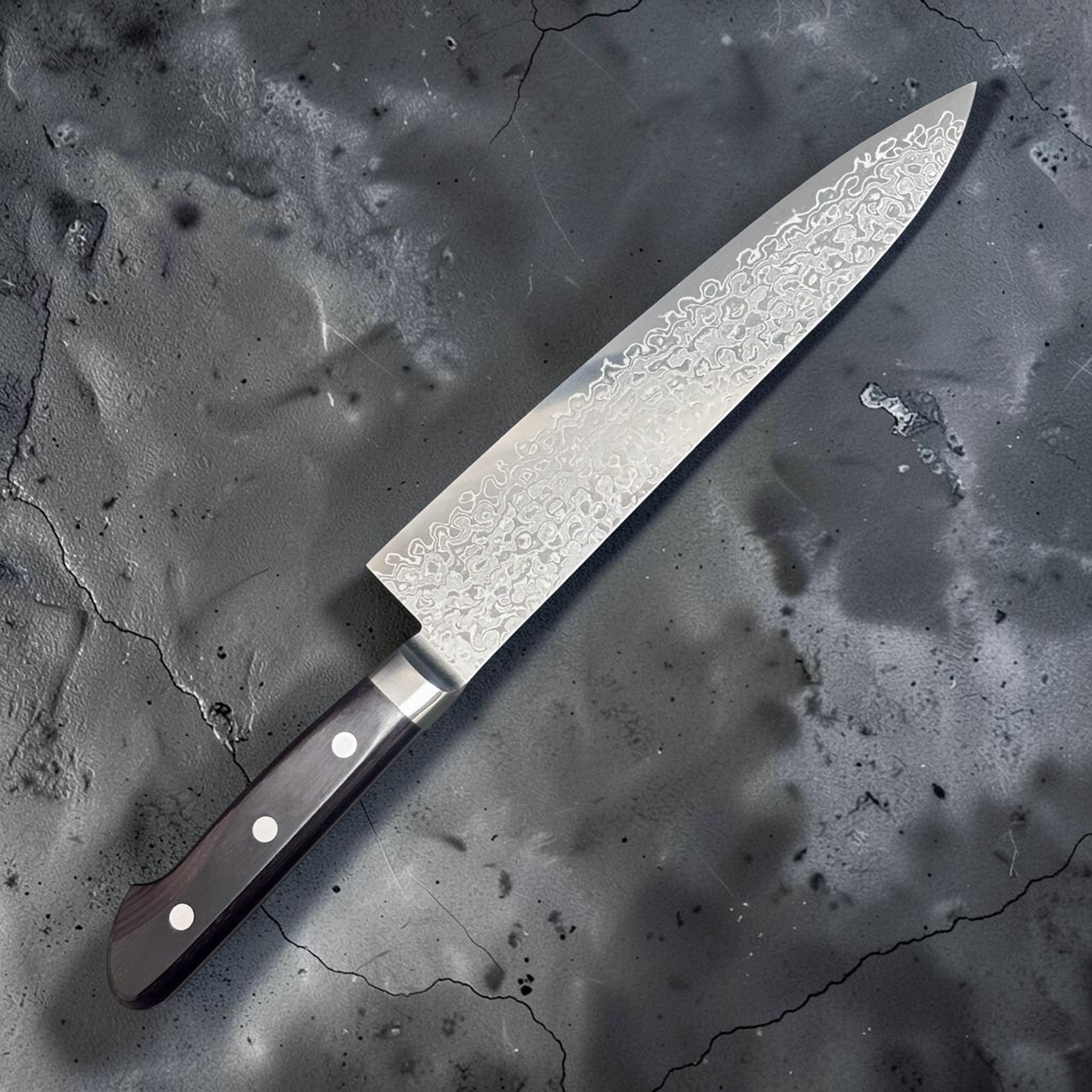 Tsunehisa AUS-10 Damascus Gyuto 210 mm, angled shot highlighting Damascus pattern and maker's mark on the blade.
