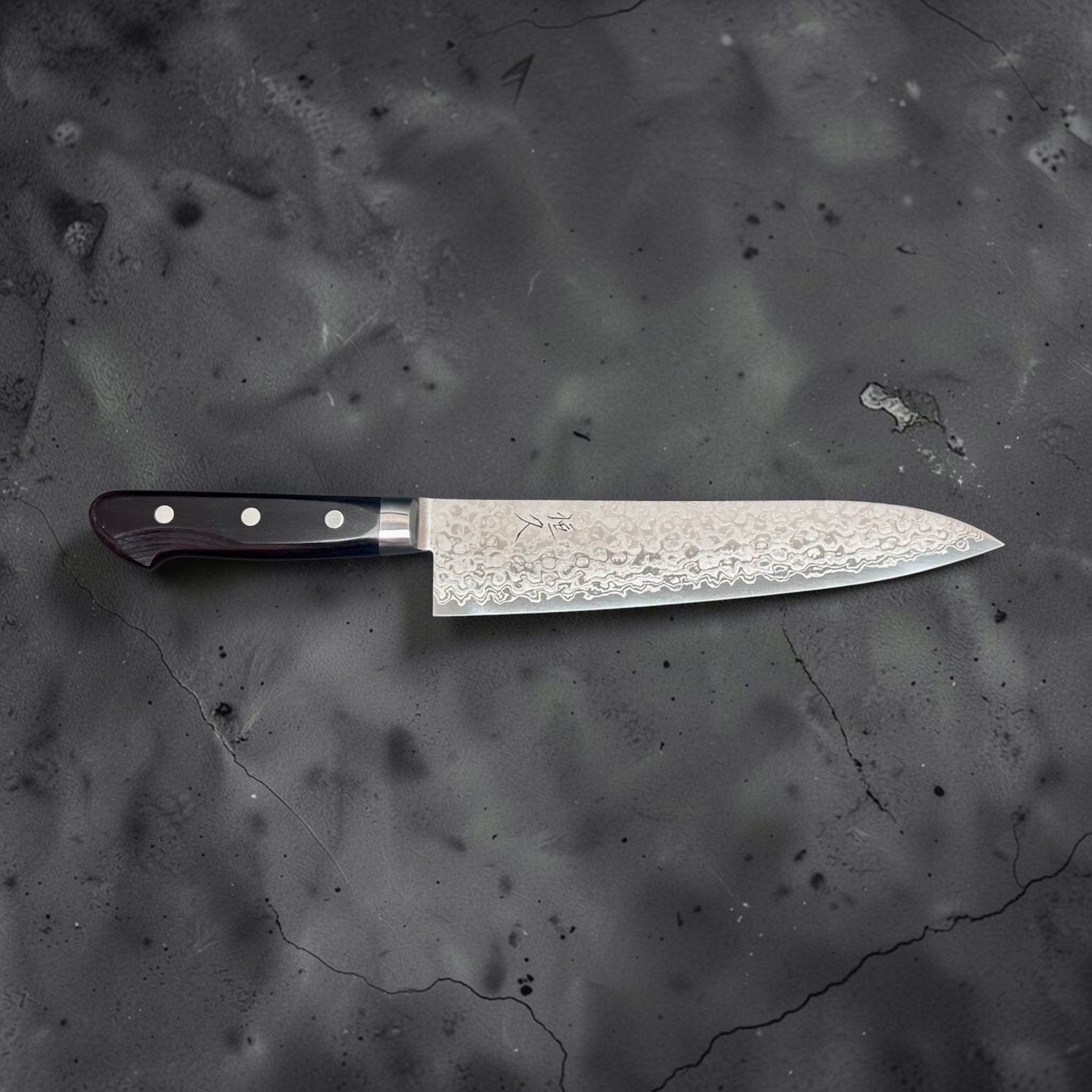 Tsunehisa AUS-10 Damascus Gyuto 210 mm, side profile view with the full knife laid horizontally against a gray background.