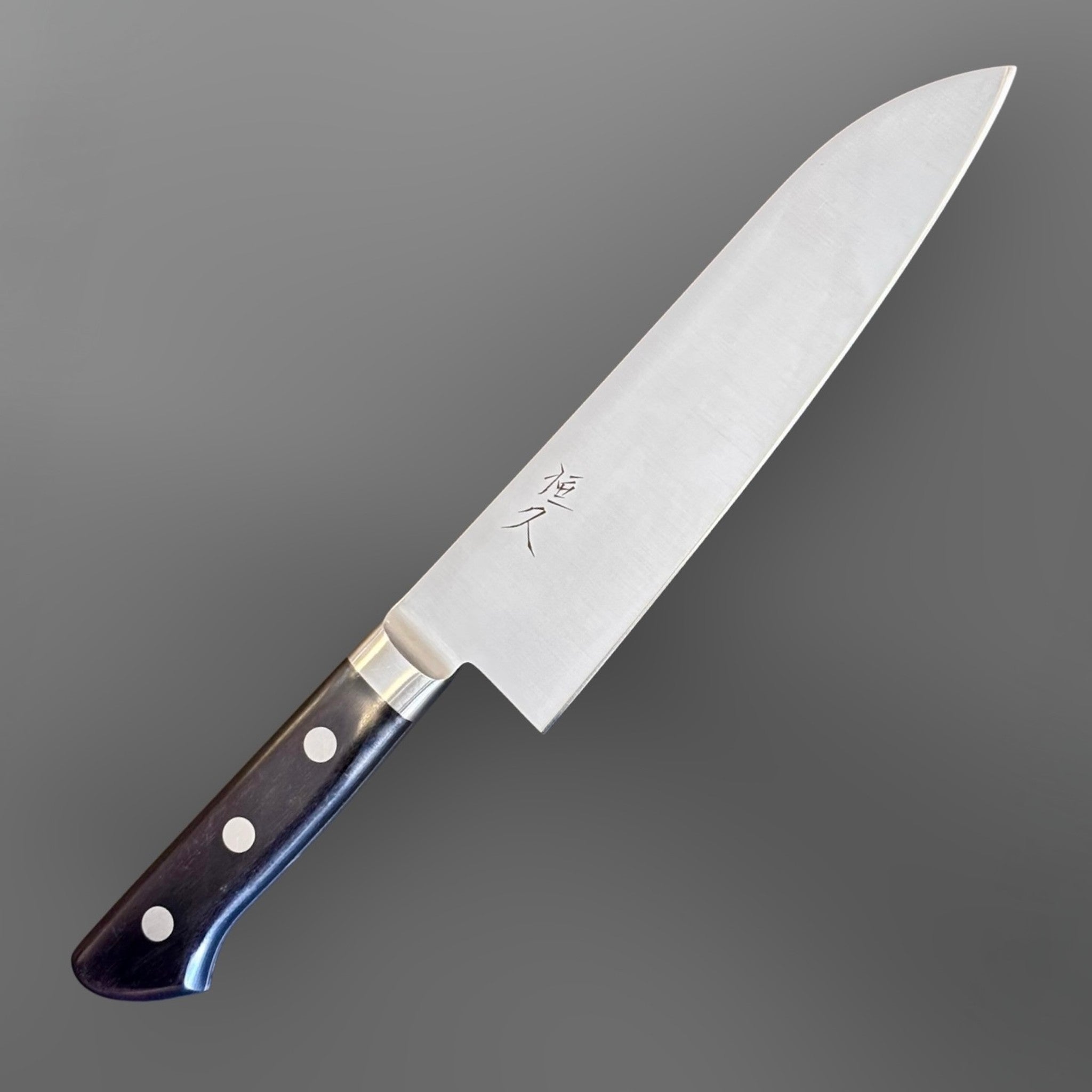 Tsunehisa Mono AUS-8 Santoku 165 mm with black Western handle, angled hero view showing the kanji mark on the blade.