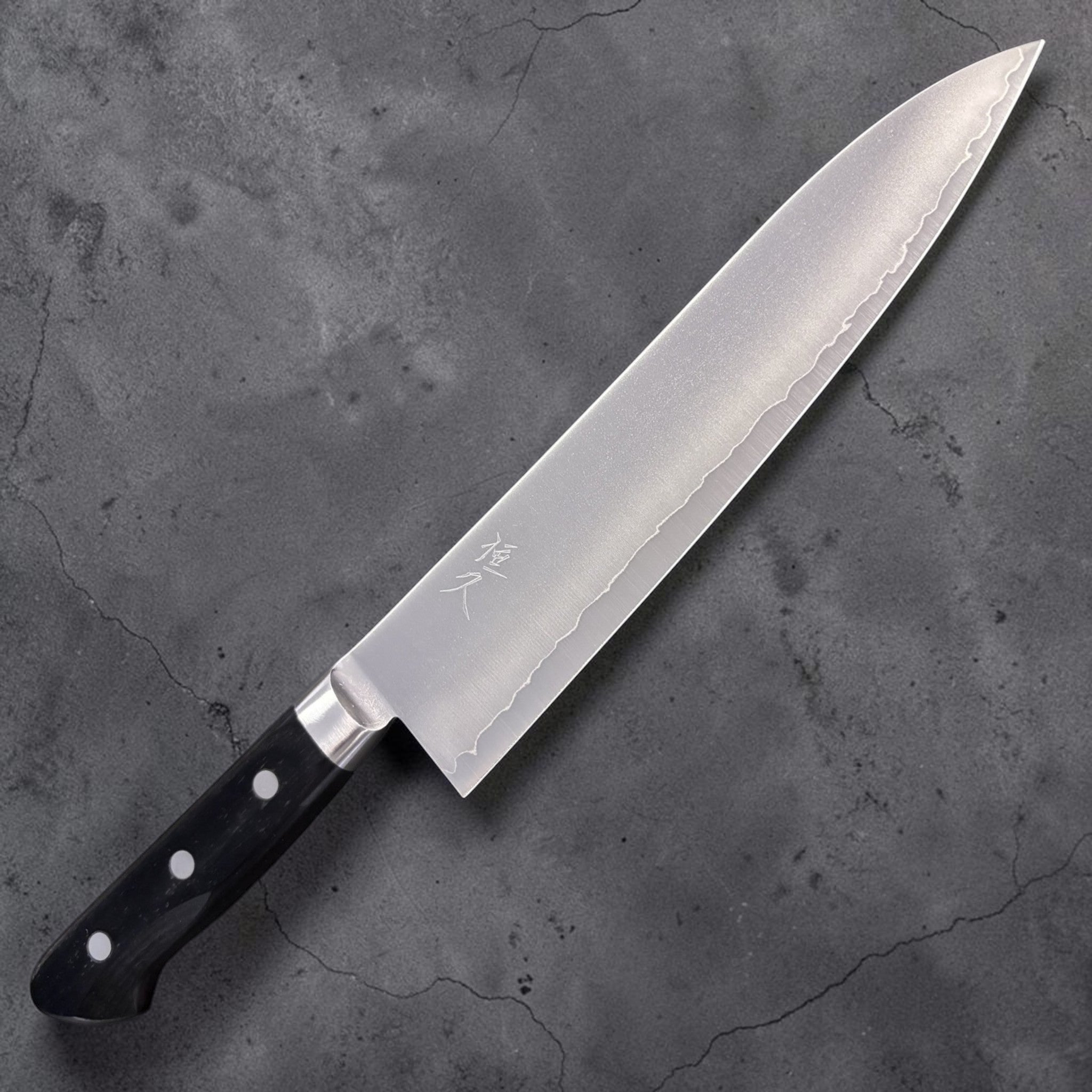 Tsunehisa VG-1 Gyuto 210 mm, front side with hamon-style cladding line and black Western handle.