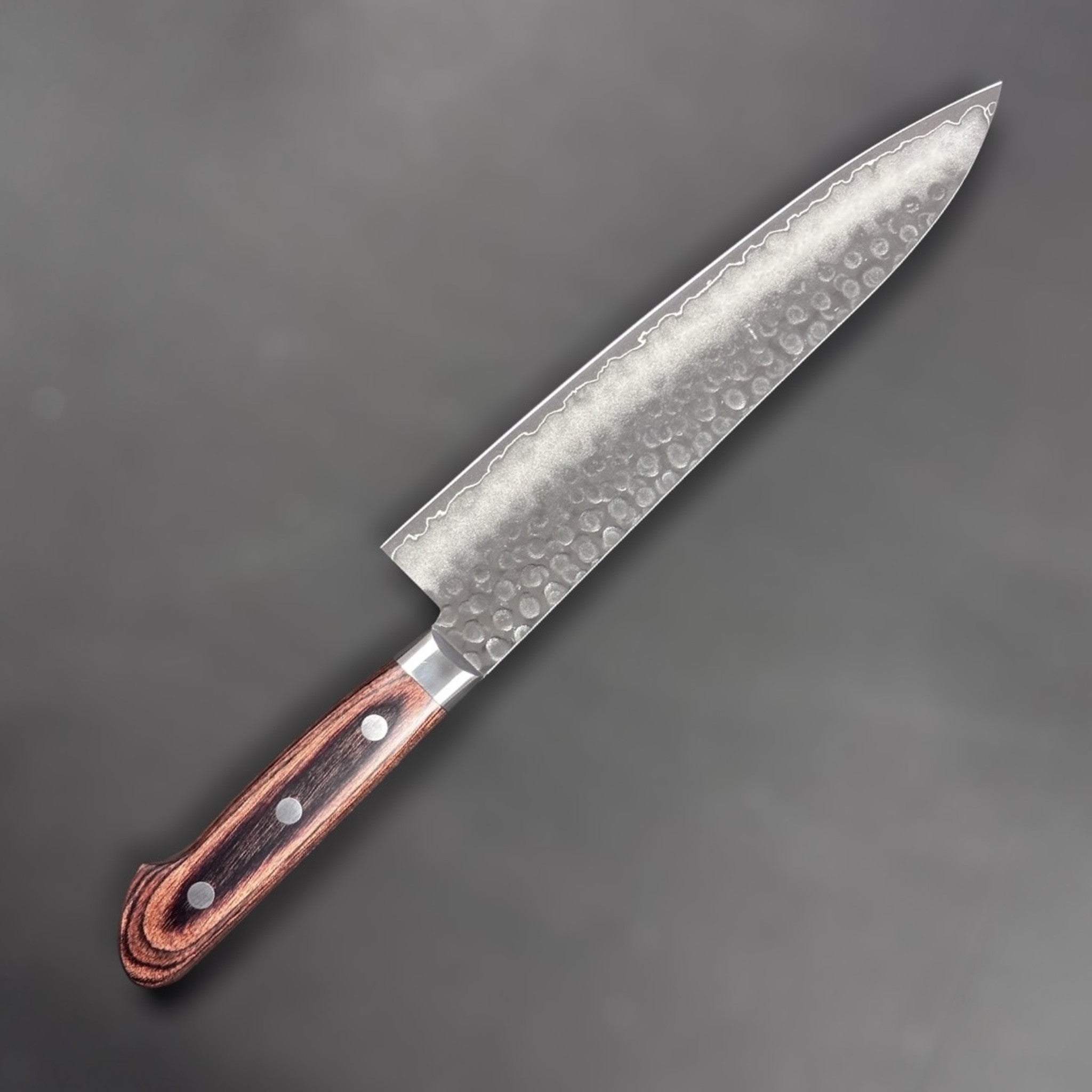 Tsunehisa VG-10 Tsuchime Gyuto 210 mm with brown Western handle, left-side face showing hammered finish and gentle cladding line.