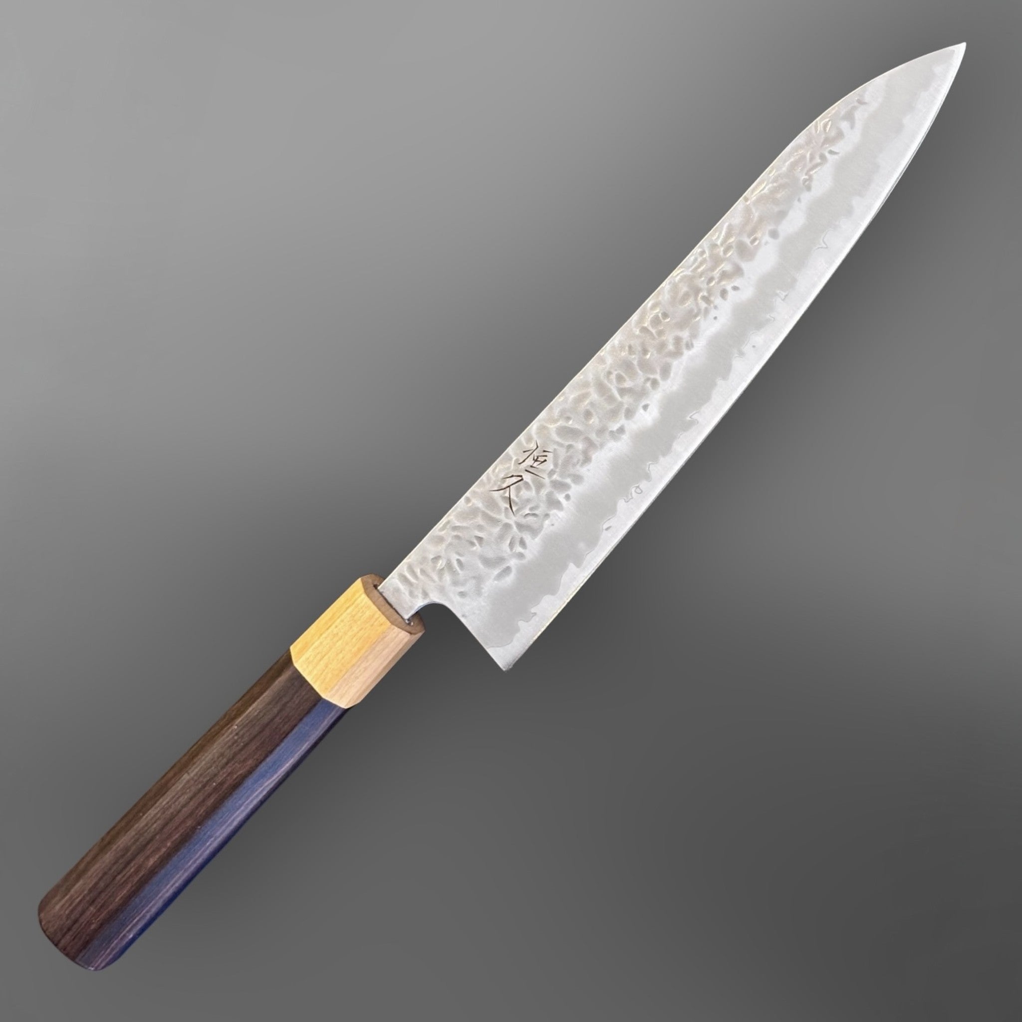 Tsunehisa White #1 stainless clad Tsuchime Gyuto 240 mm with ebony wa handle and light wood ferrule, angled full-knife product view.