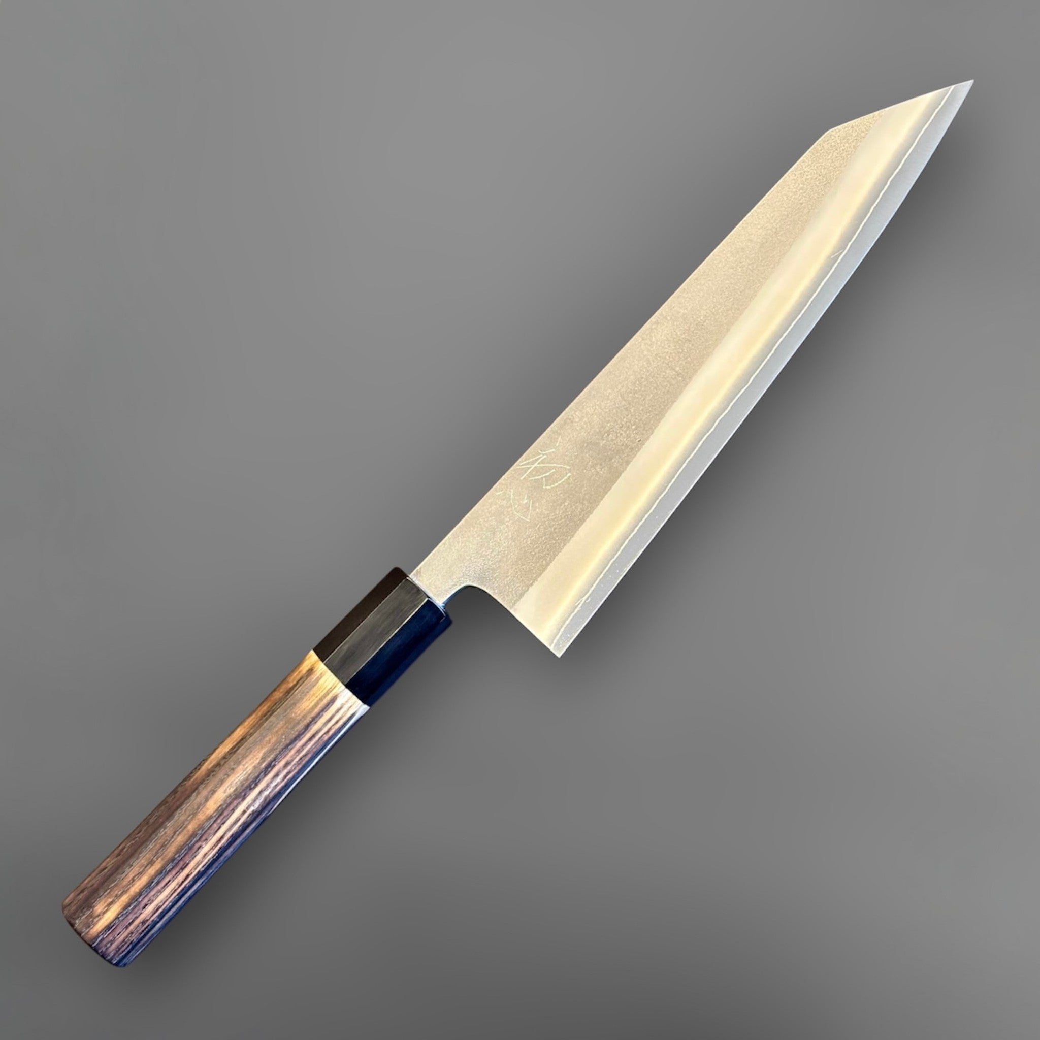 Yoshikane SKD Nashiji Kiritsuke 210 mm with burnt wood and black buffalo horn handle, angled front view on gray background.
