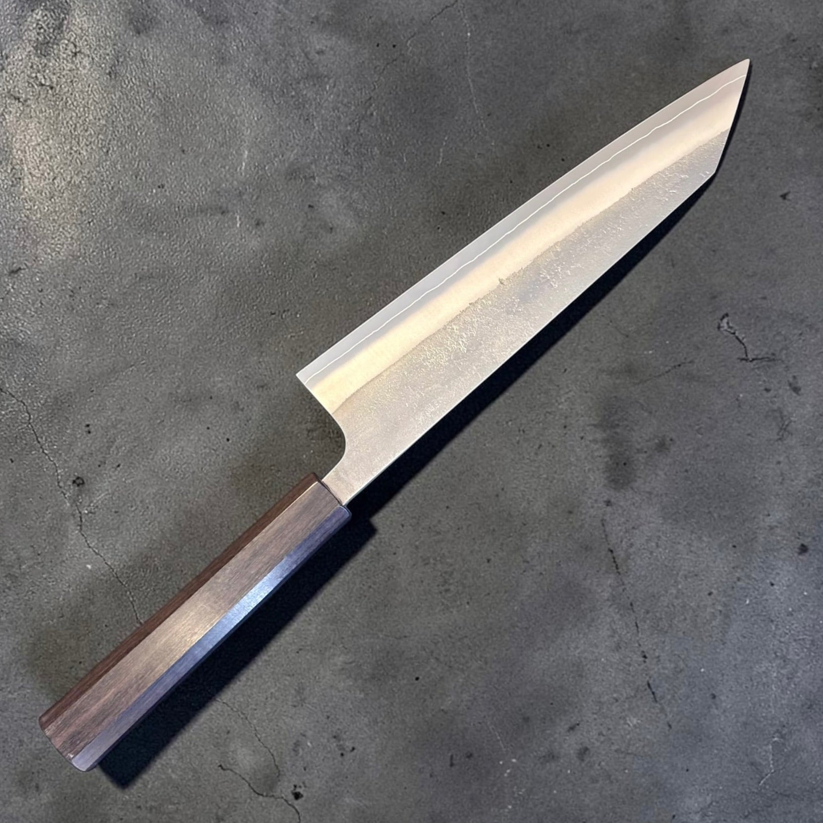 Yoshikane SKD Nashiji Kiritsuke 210mm with mono bubinga handle, angled reverse-side view.