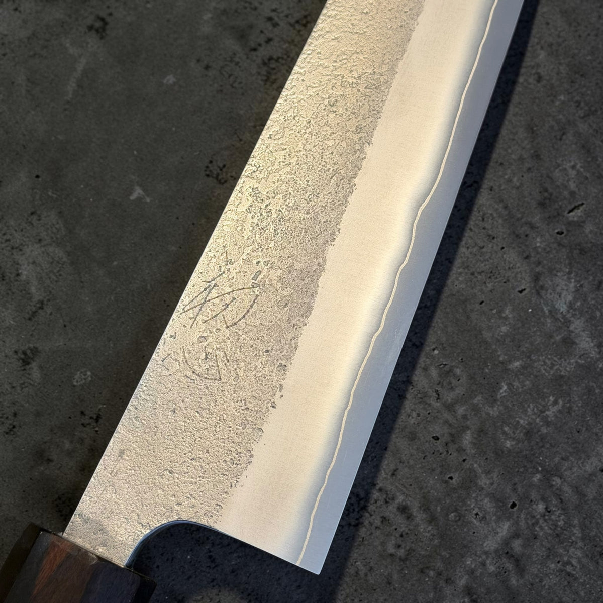 Yoshikane SKD Nashiji Gyuto 240mm blade close-up showing the nashiji finish, cladding line and kanji.