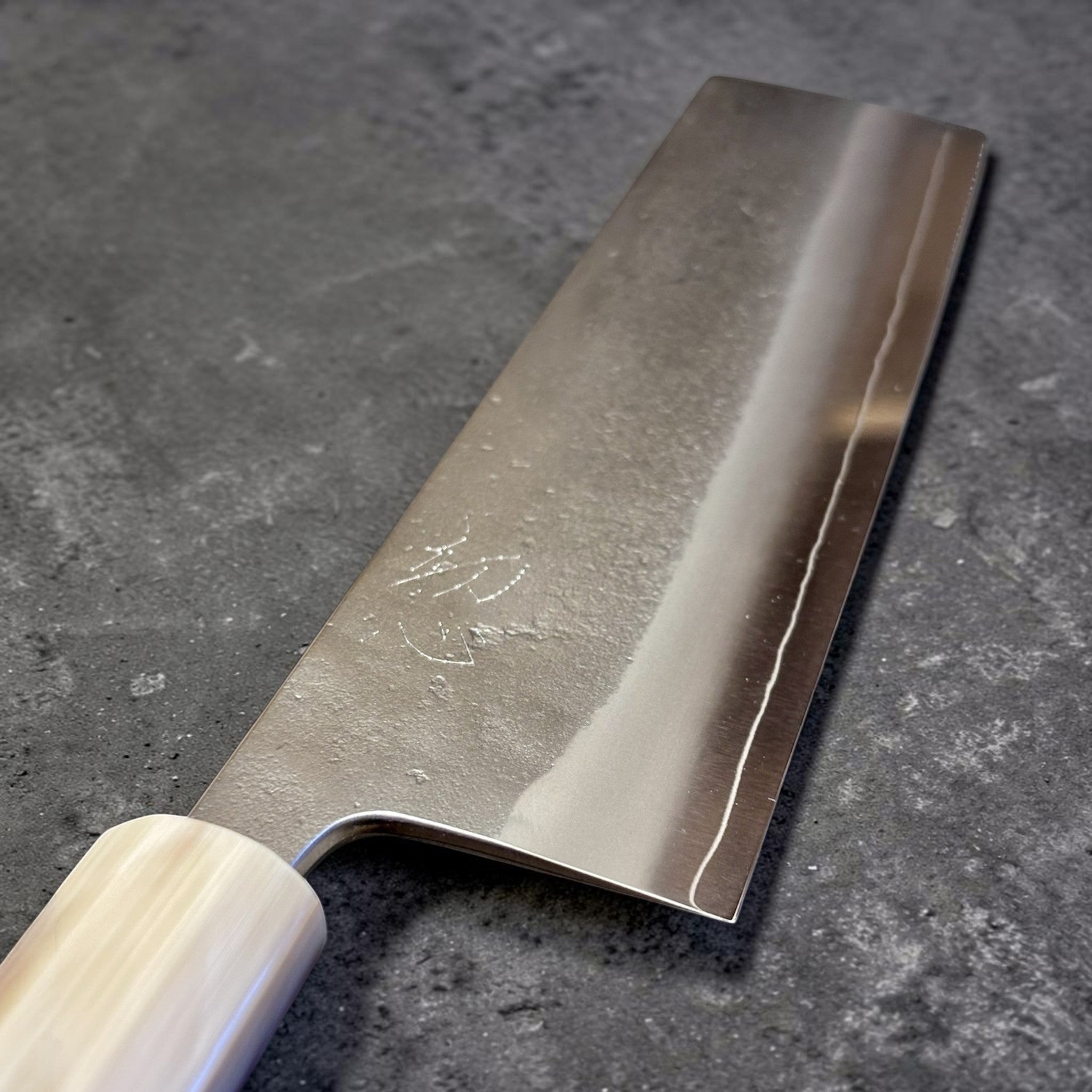 Yoshikane SKD Nashiji Nakiri with amboyna burl handle, close-up of the blade finish and edge line.
