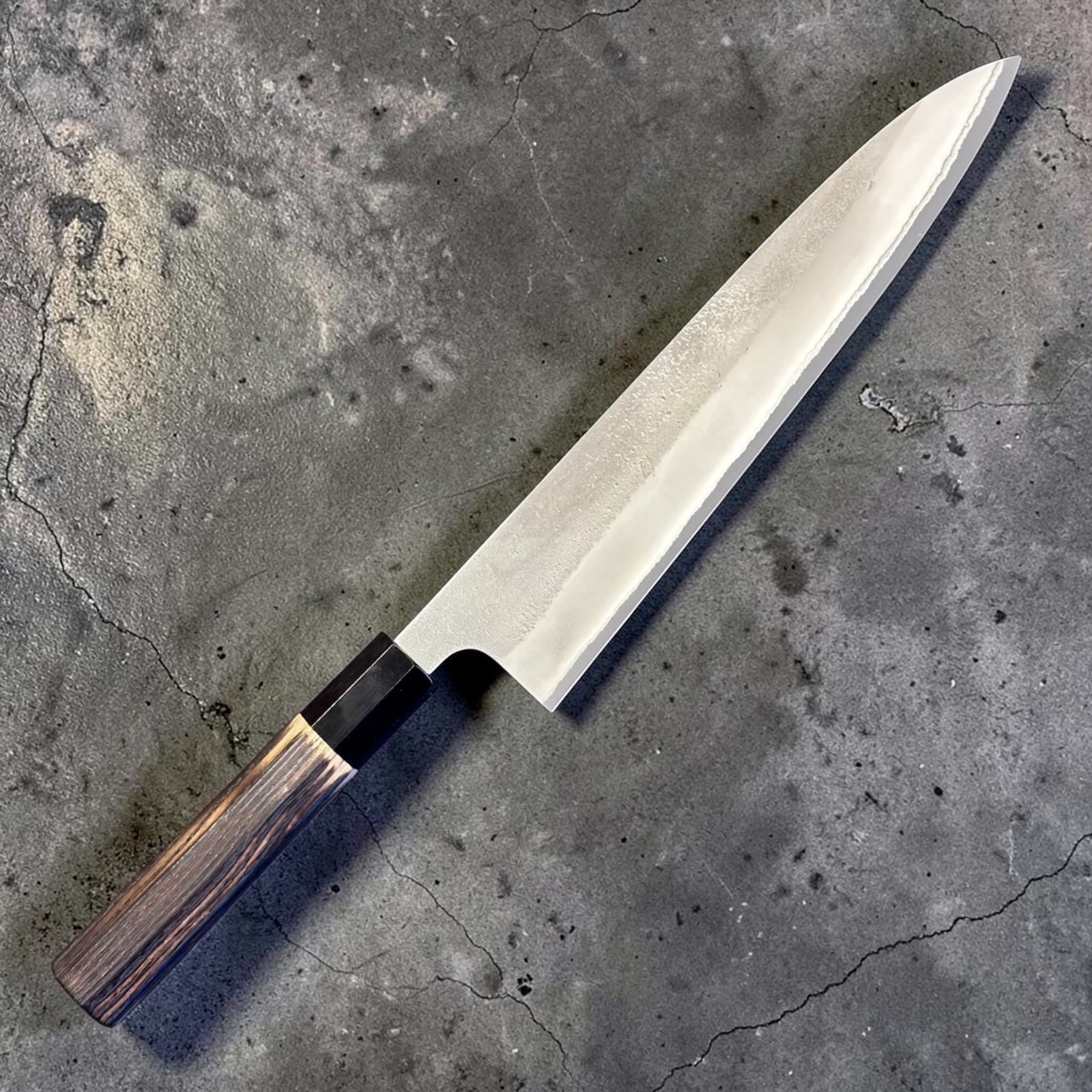 Yoshikane White #2 Nashiji Gyuto 240 mm, angled full-length view of the knife with octagonal burnt wood wa handle and black buffalo horn ferrule.