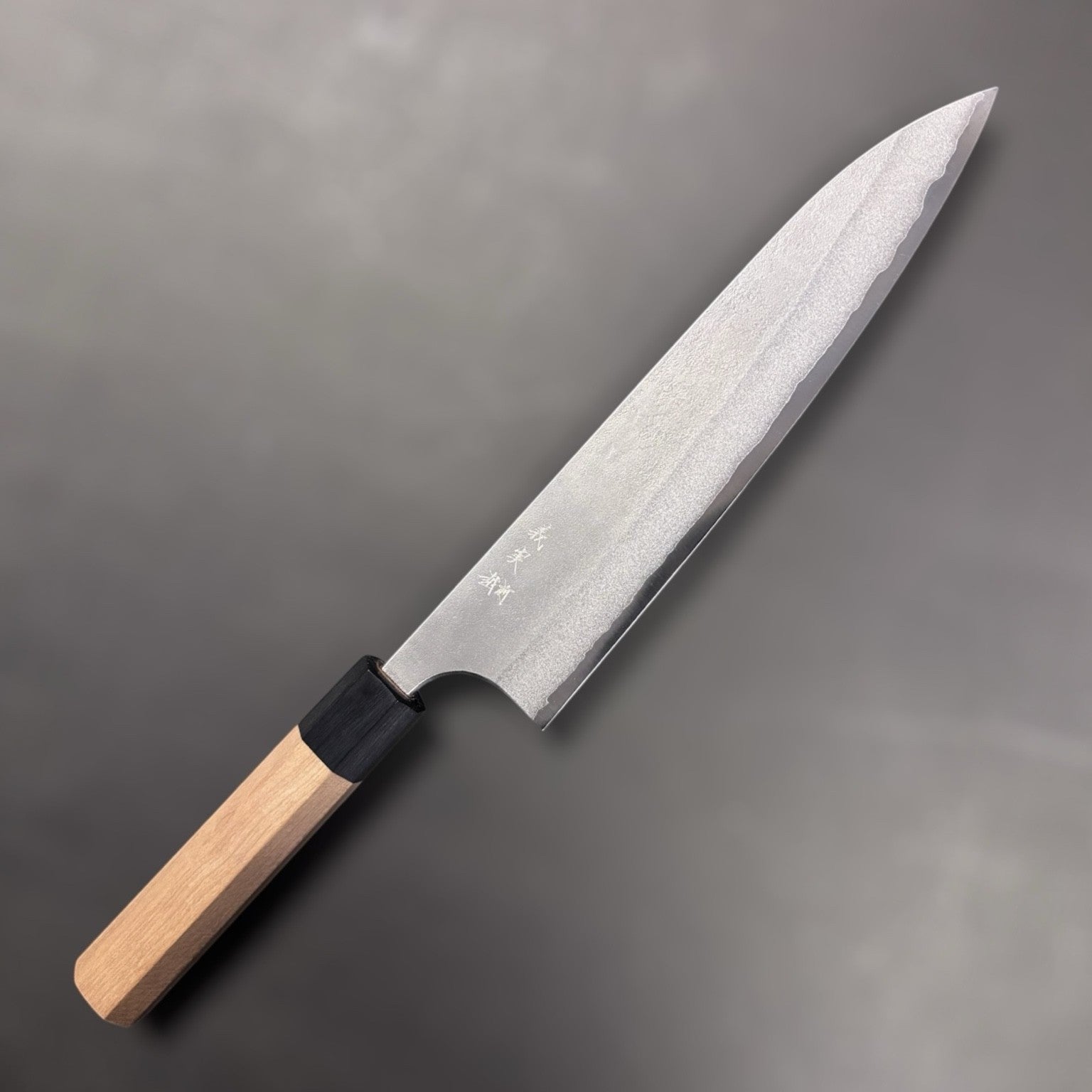 Yoshimi Kato AS Nashiji Gyuto 240mm, right side angled shot highlighting edge geometry and forged Nashiji pattern.