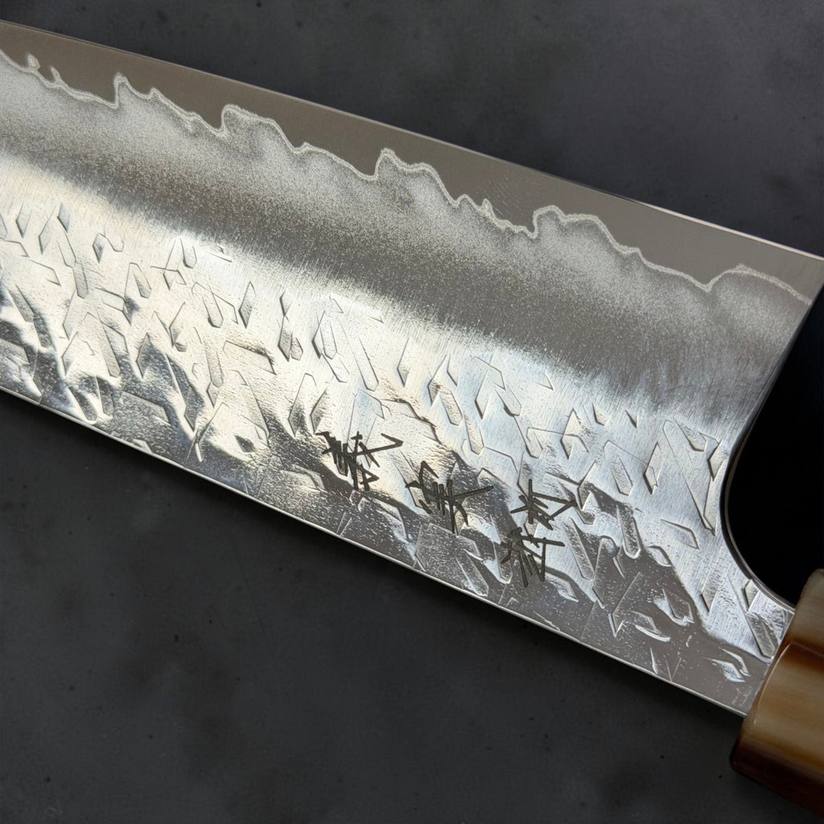 Close-up of Yoshimi Kato maker engraving, angular Hyo hammer marks and polished bevel