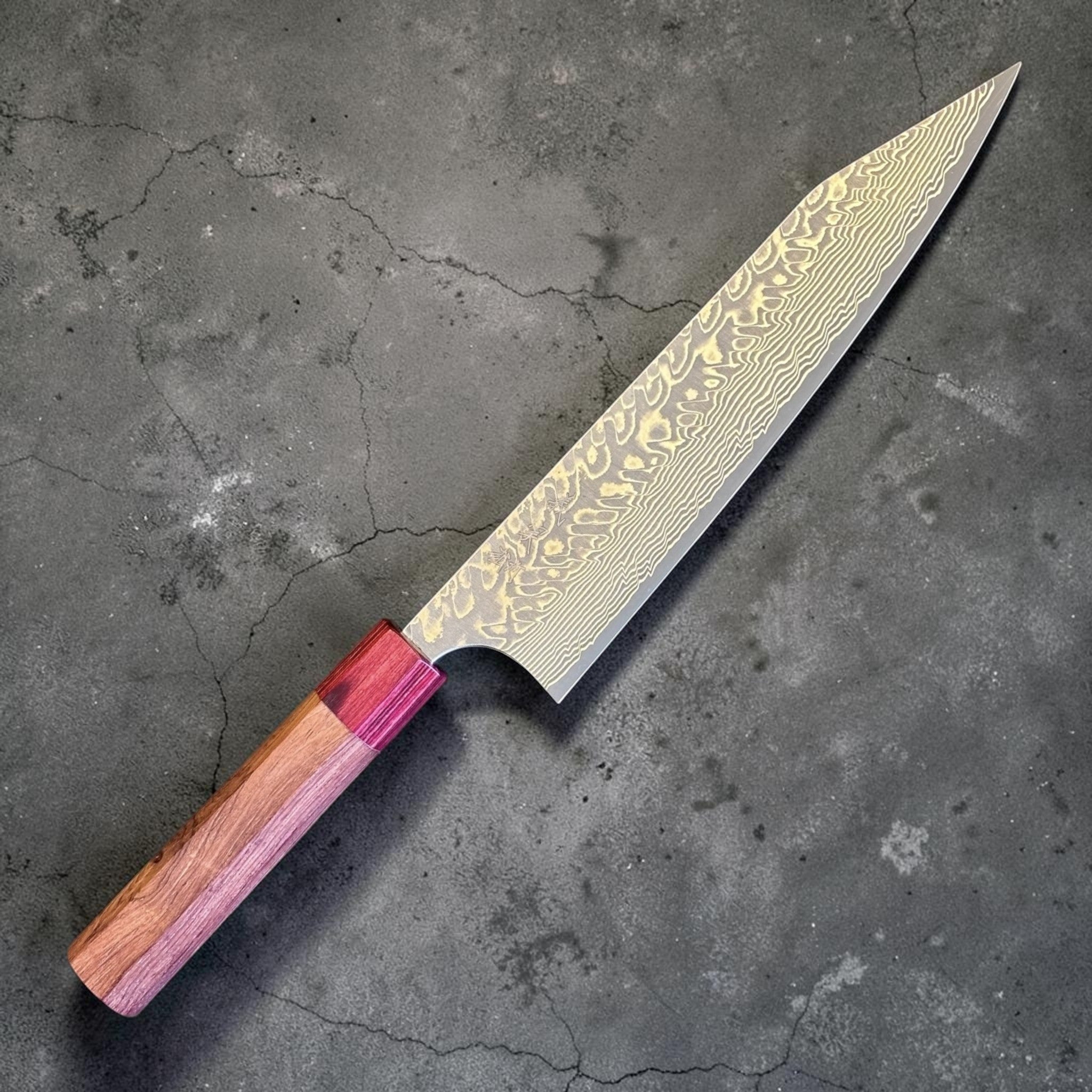 Yoshimi Kato SG2 Kuro Damascus Kiritsuke 210 mm with Honduran wood handle, close angled view of the kiritsuke tip and patterned blade face.