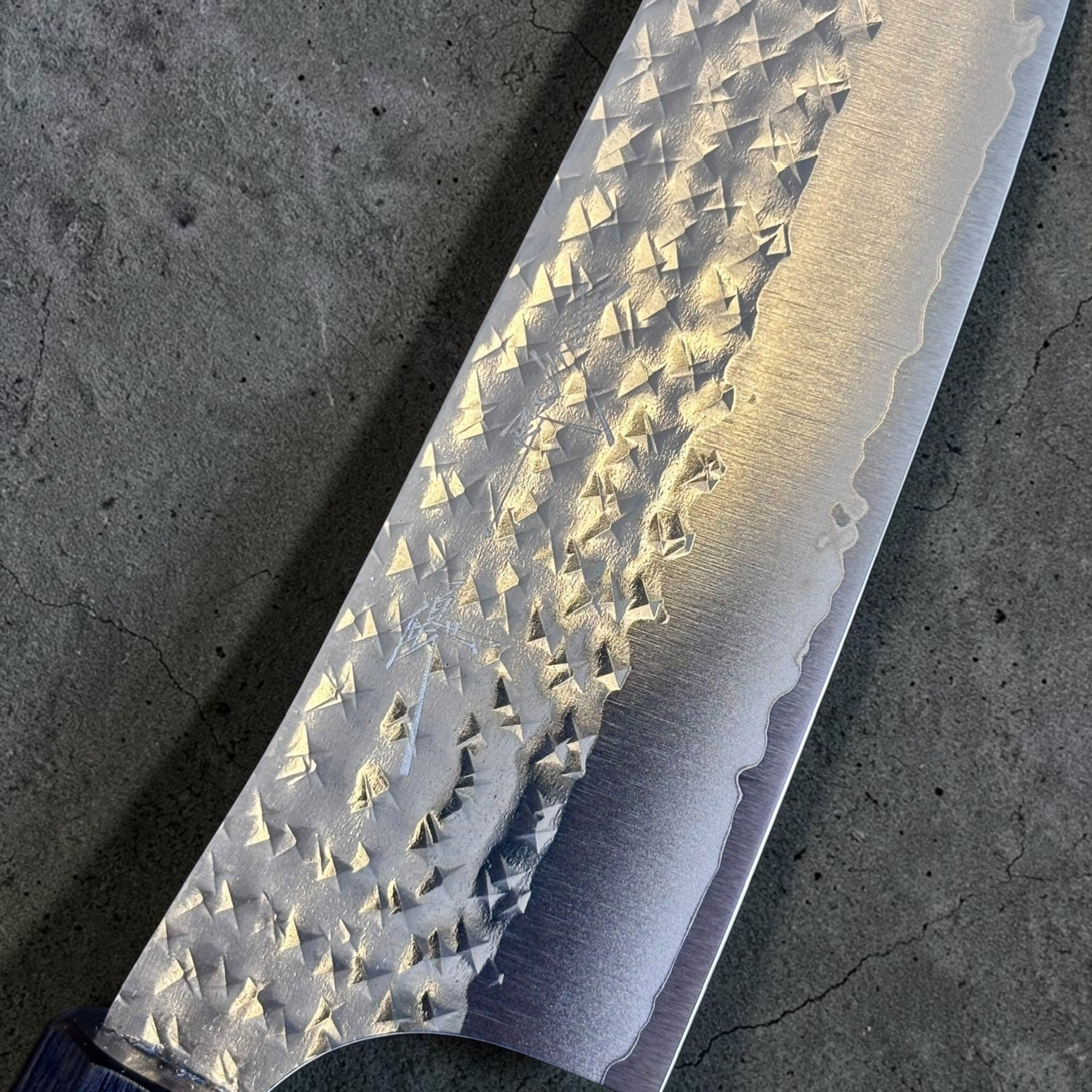 Close-up of the Yu Kurosaki Kokusen AS Bunka 165mm hammered blade finish and cladding line