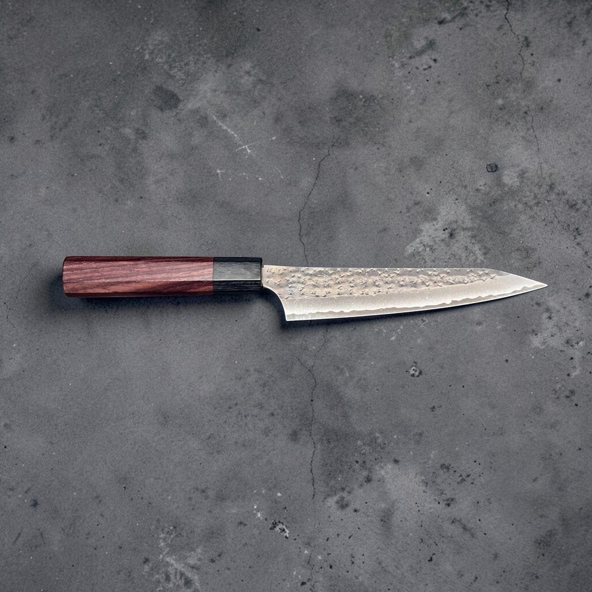 Yu Kurosaki Kokusen AS Petty 150 mm with rosewood octagon wa handle, horizontal side profile showing the slim 150 mm blade, hammered texture, and rosewood handle.