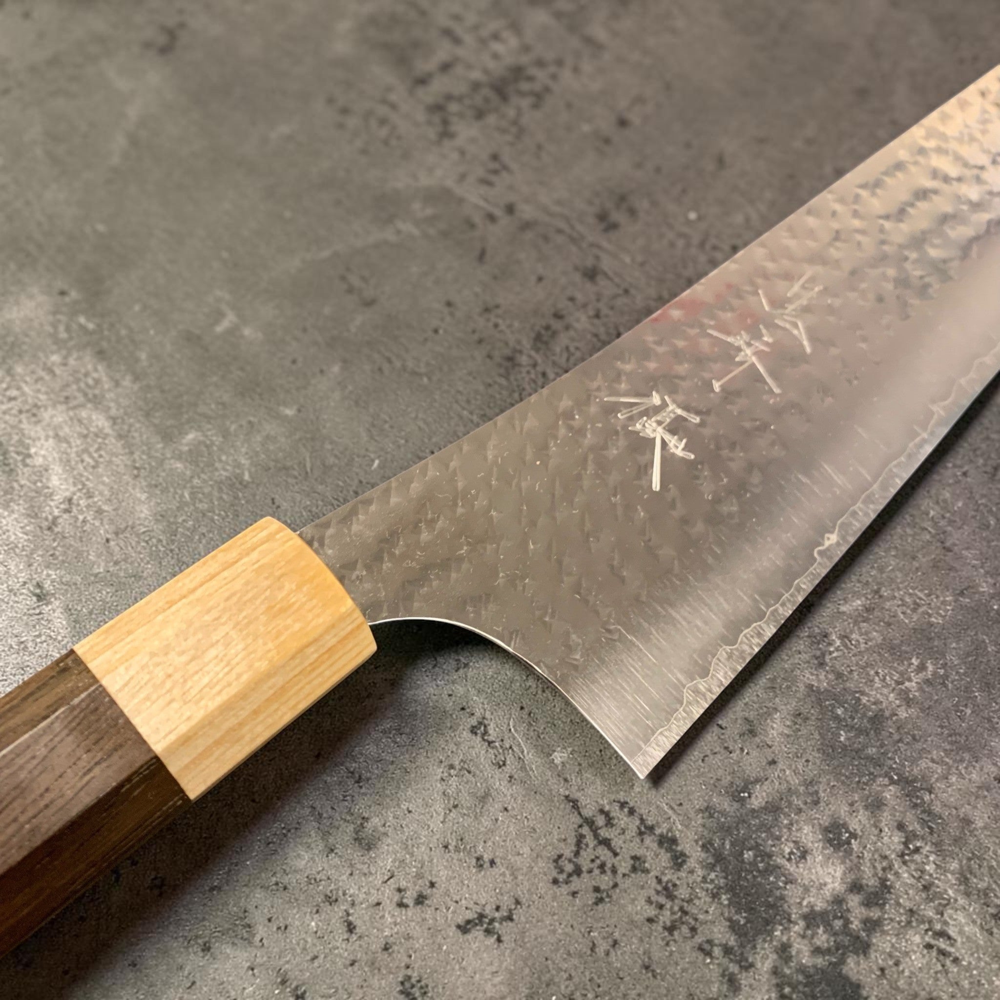 Yu Kurosaki Senko Ei SG2 Gyuto 240 mm — product angle highlighting tsuchime hammer pattern and satin hairline finish.