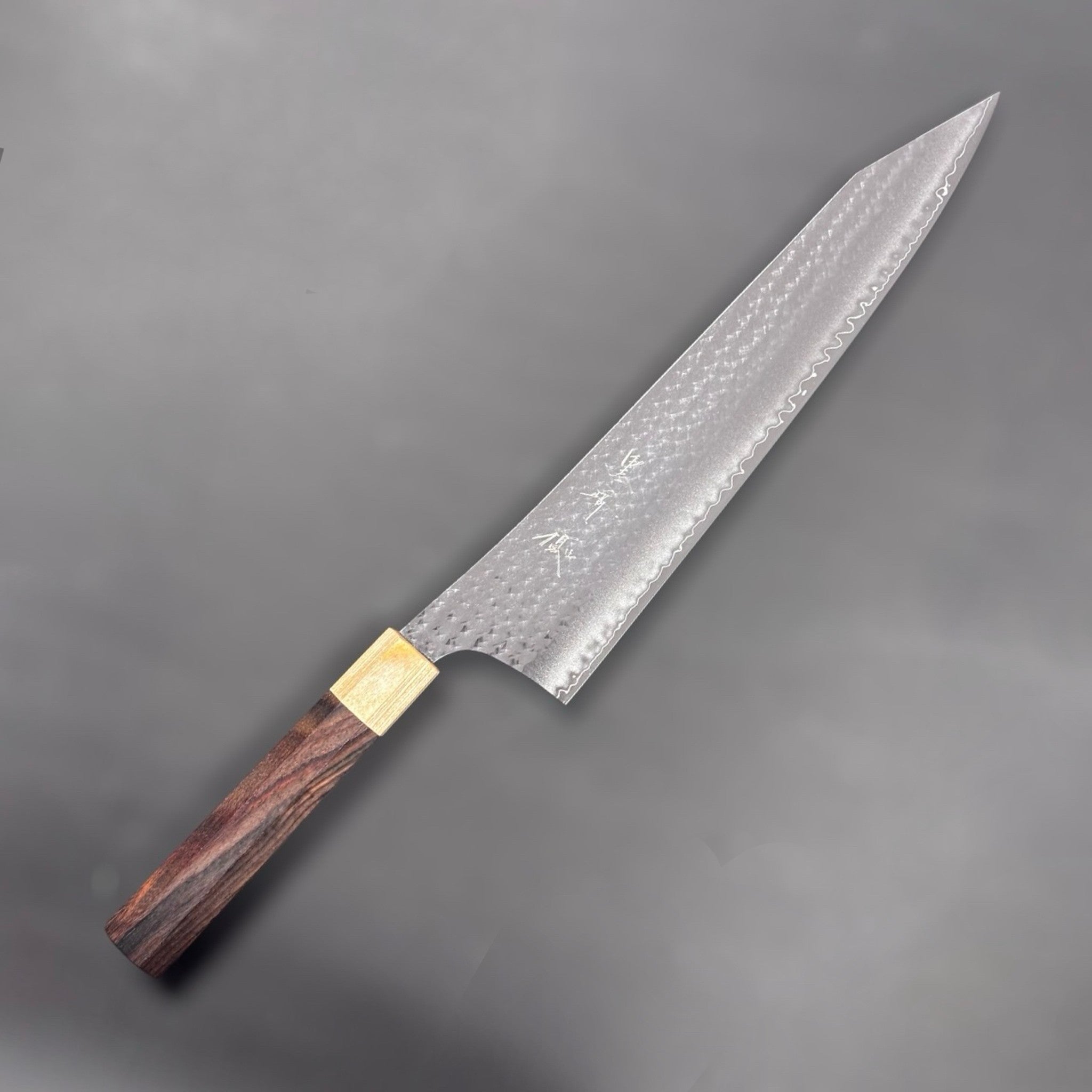 Yu Kurosaki Senko Ei SG2 Gyuto 270mm, angled view highlighting hammered pattern and tip.