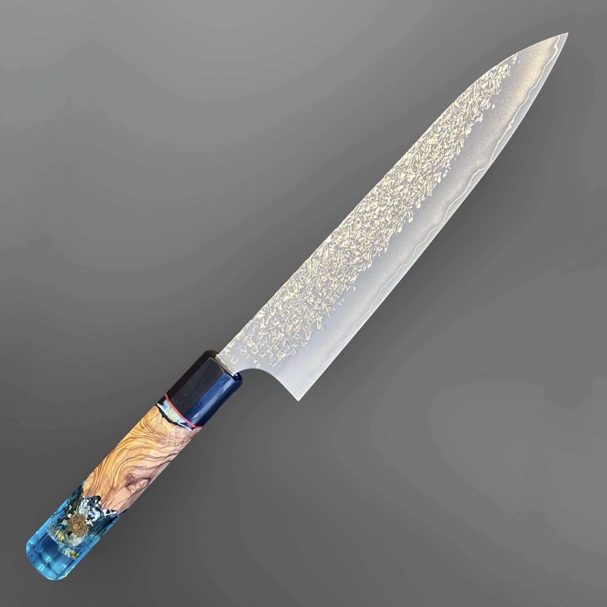 Yu Kurosaki Shizuku SG2 Gyuto 210 mm Custom with Prisma Knife Mountain Spring Handle, alternate angled product photo highlighting the SG2 blade finish and blue resin-and-wood custom handle.
