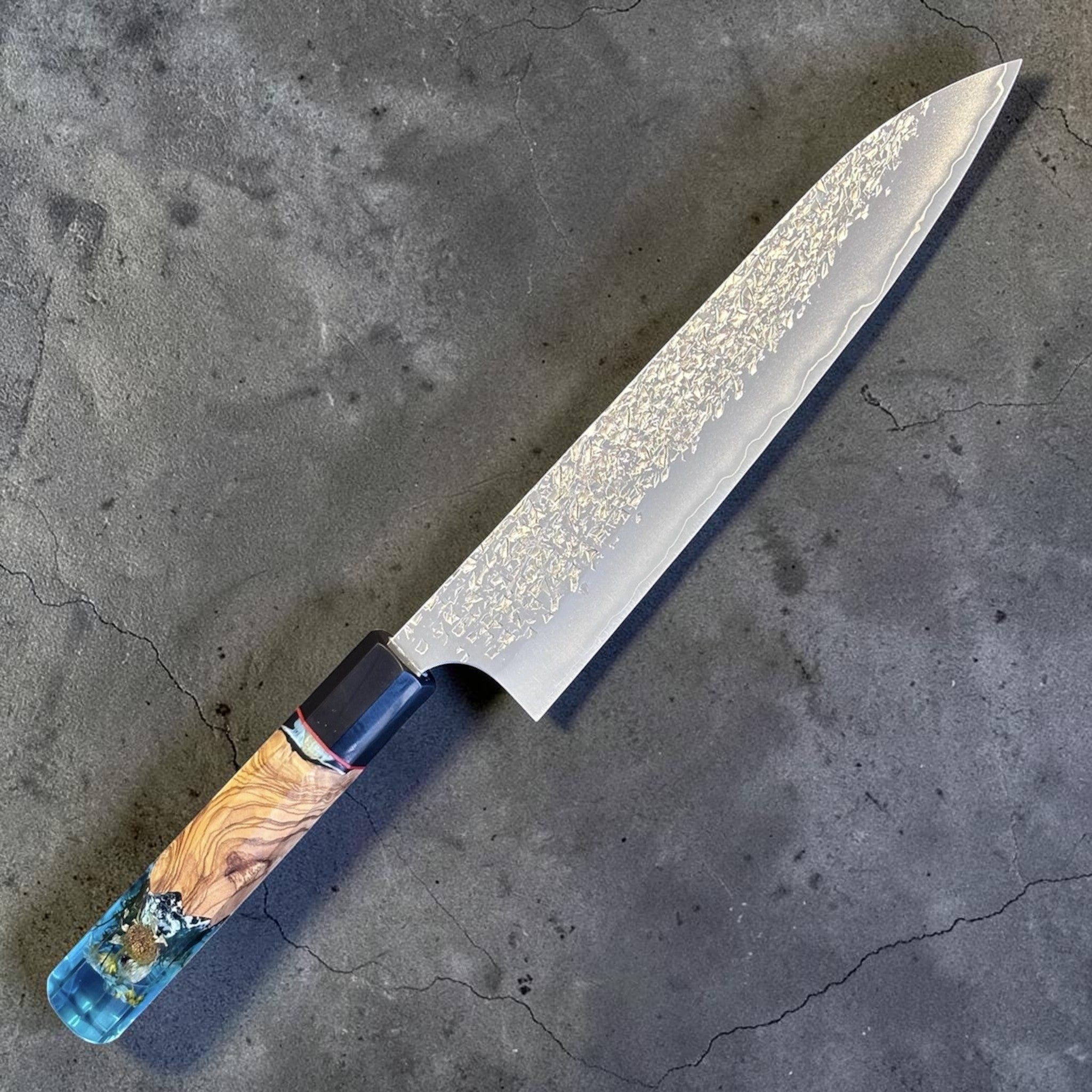Yu Kurosaki Shizuku SG2 Gyuto 210 mm Custom with Prisma Knife Mountain Spring Handle, alternate angled product photo highlighting the SG2 blade finish and blue resin-and-wood custom handle.