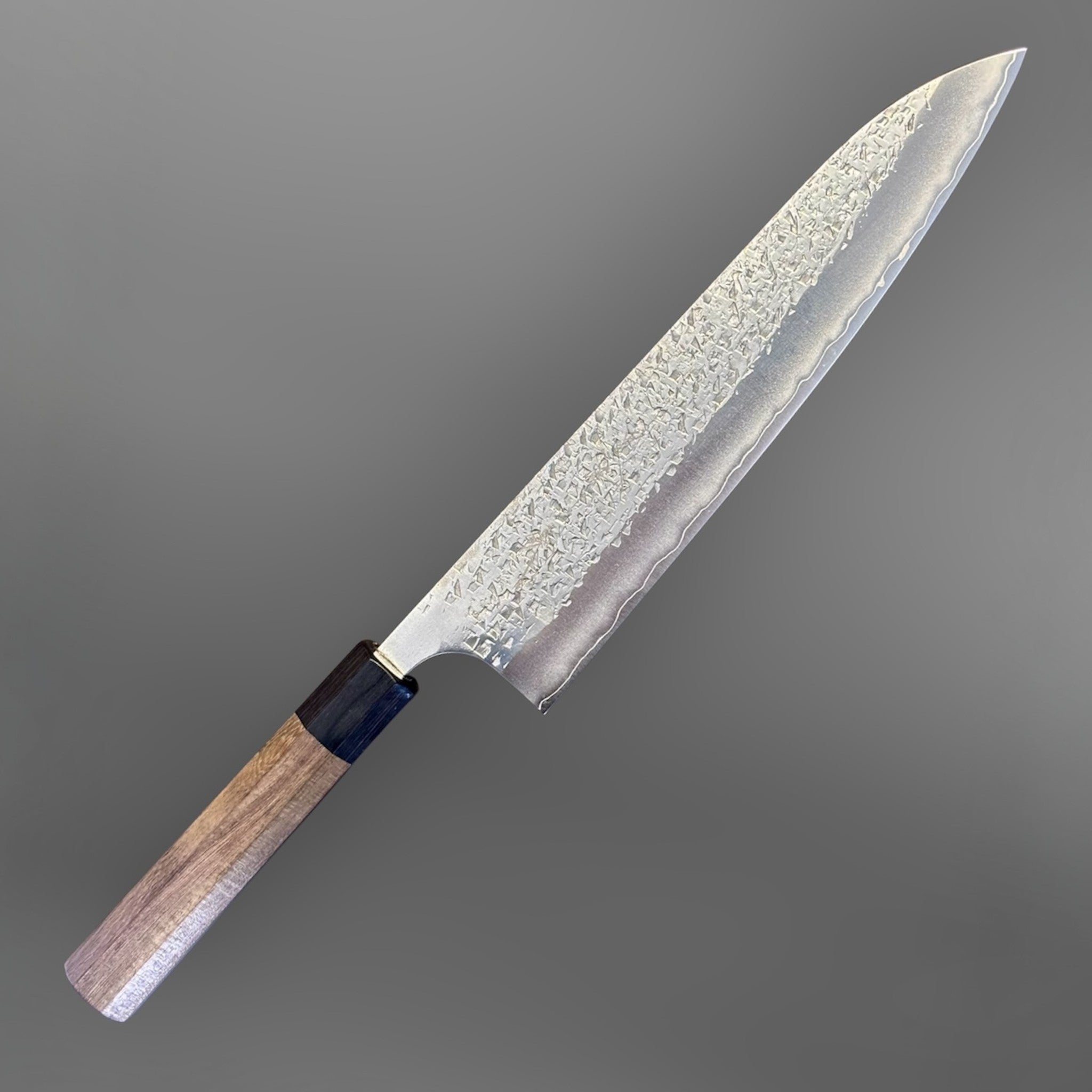 Yu Kurosaki Shizuku SG2 Gyuto 240 mm, angled full-knife view showing the hammered blade and wa handle.