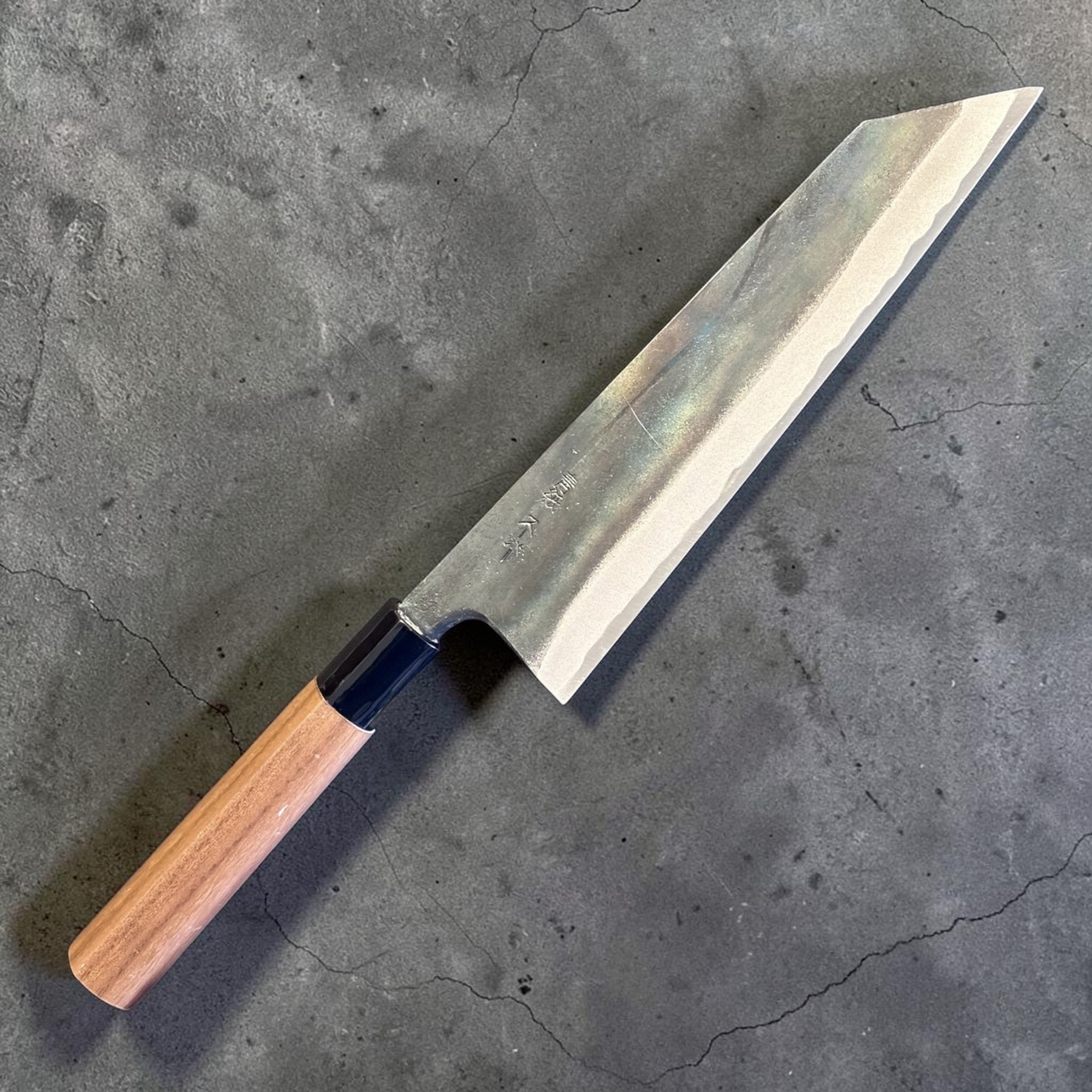 Zakuri AS Kurouchi Bunka 180 mm with kurouchi finish and wa handle, angled product photo showing the bunka tip and blade finish.