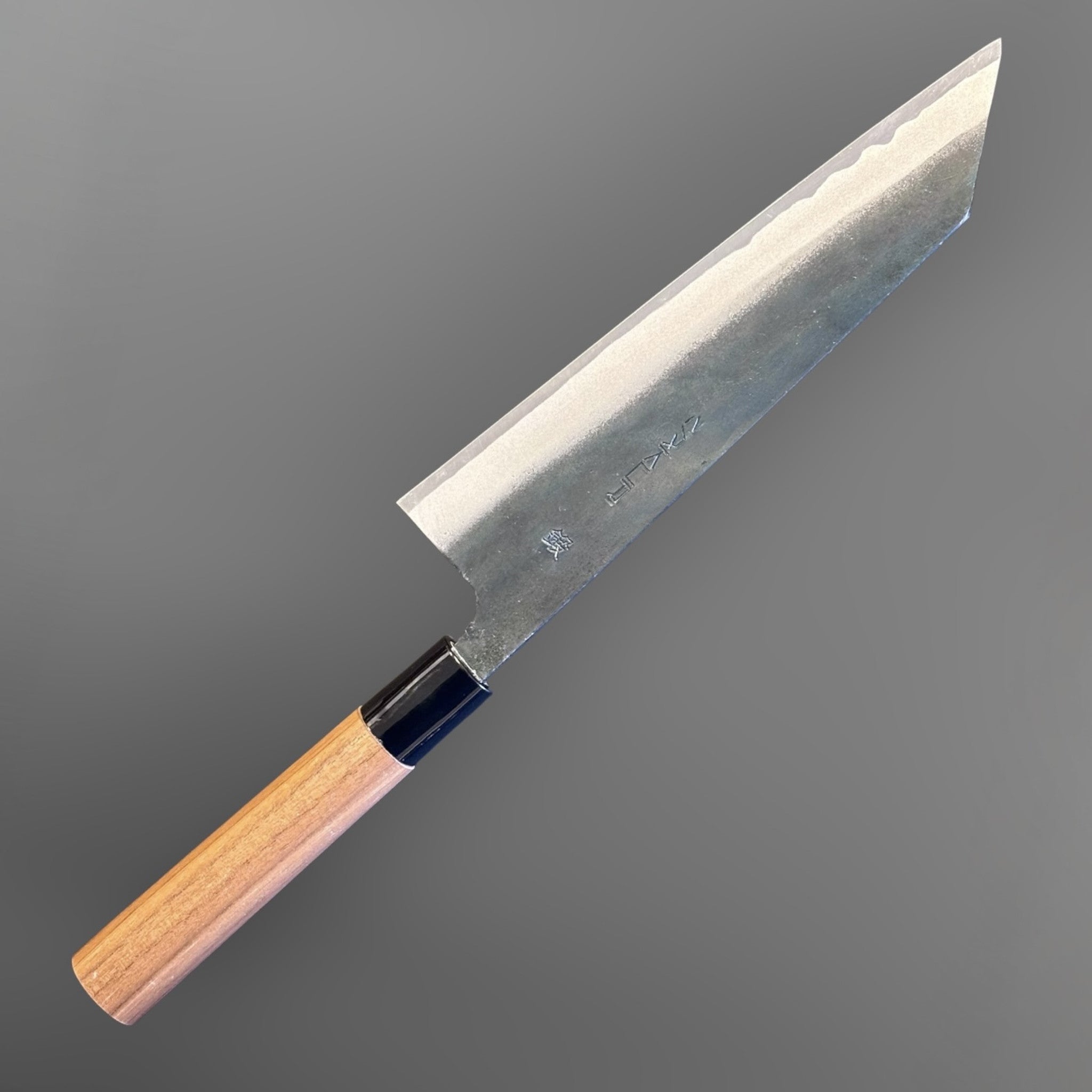 Zakuri AS Kurouchi Bunka 180 mm with kurouchi finish and wa handle, angled product photo showing the bunka tip and blade finish.