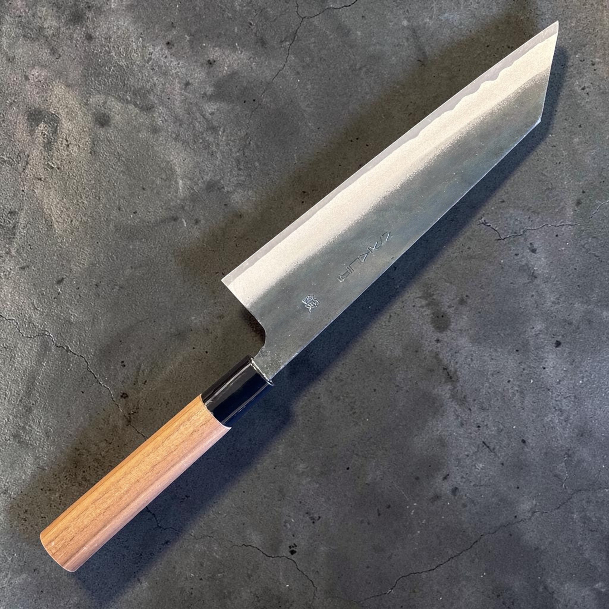 Zakuri AS Kurouchi Bunka 180 mm with kurouchi finish and wa handle, angled product photo showing the bunka tip and blade finish.
