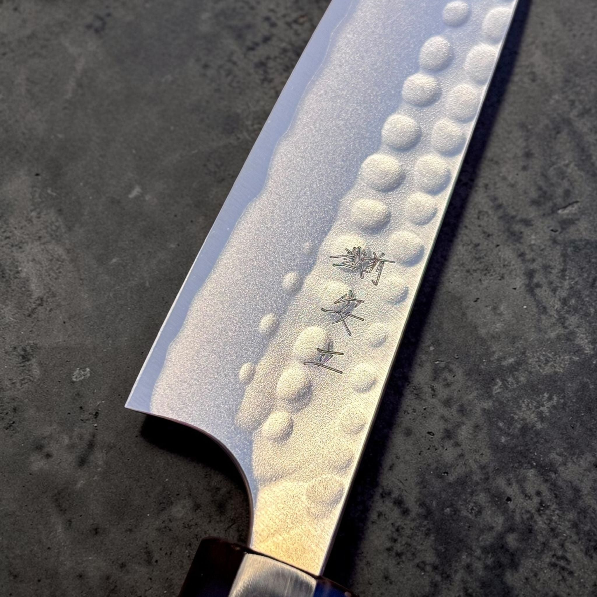 Anryu Aogami #2 Tsuchime Petty 120 mm with burnt wood handle and black buffalo horn ferrule, close-up of hammered tsuchime blade face and maker's kanji.
